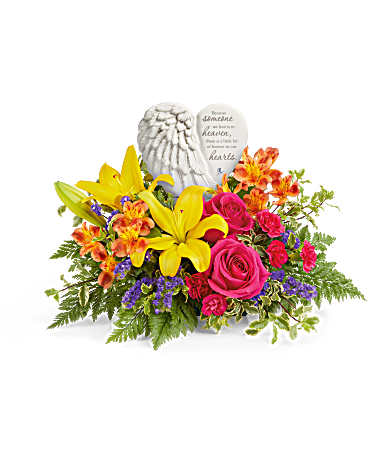 Teleflora's Forever In Bloom Bouquet - A heartfelt tribute to a cherished life, this stunning arrangement of vibrant blooms beautifully surrounds the Heaven's Heart Keepsake. Featuring a delicate angel wing design, this touching porcelain keepsake offers comfort and love, making it a treasured reminder of precious memories. This arrangement features hot pink roses, yellow Asiatic lilies, orange alstroemeria, hot pink miniature carnations, purple sinuata statice, leatherleaf fern, and pitta negra. Arranged with the Heaven's Heart Keepsake, this beautiful tribute offers comfort and remembrance.