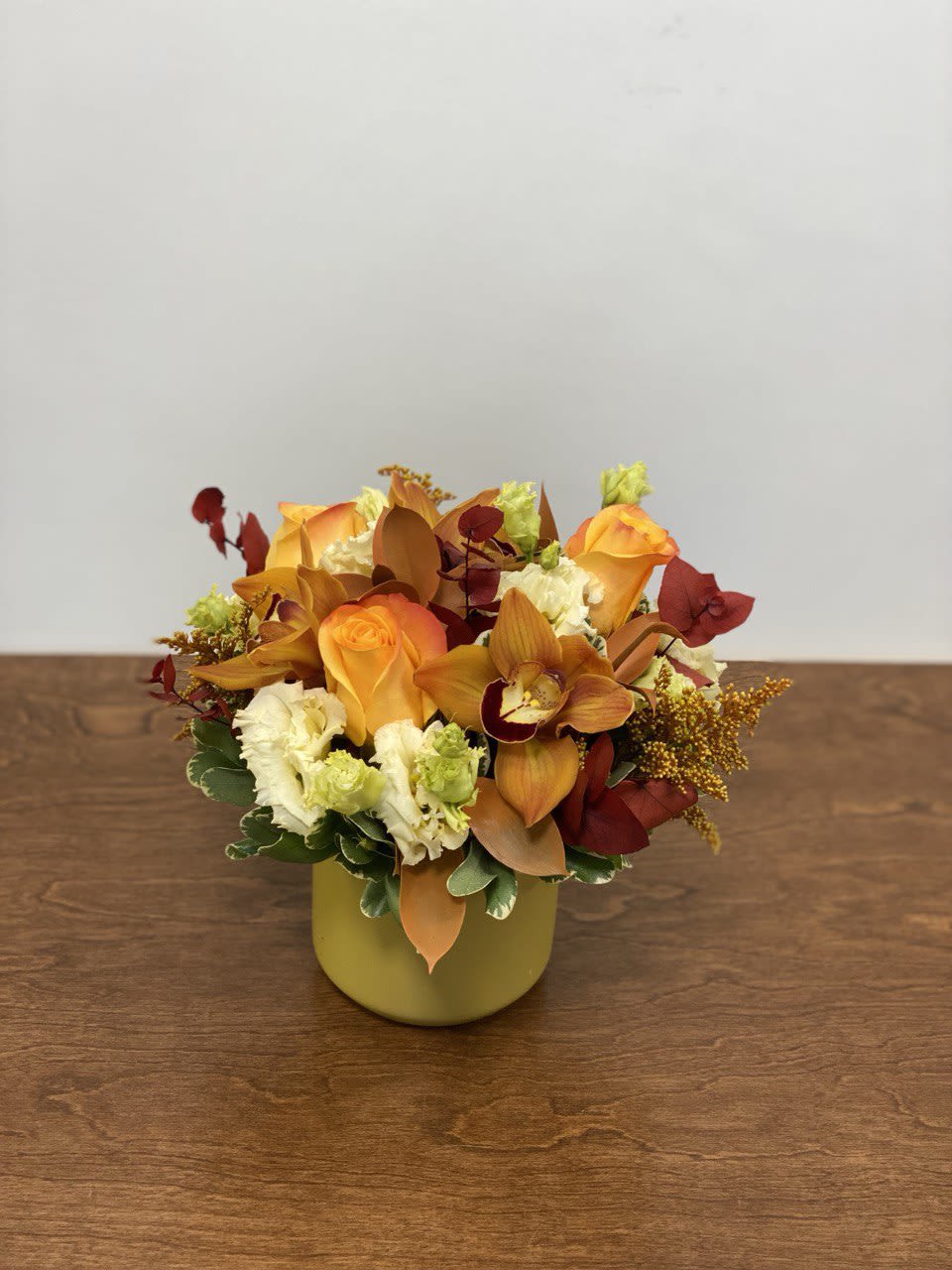 Autumn Glow Autumn Glow - Warm and radiant, Autumn Glow captures the cozy beauty of the fall season. This arrangement blends golden-orange roses, amber cymbidium orchids, creamy lisianthus, and textured foliage in rich autumn tones. Designed in a soft mustard vase, it brings a touch of seasonal elegance to any space — perfect for Thanksgiving gatherings, a heartfelt gift, or simply brightening your home with fall’s golden charm.