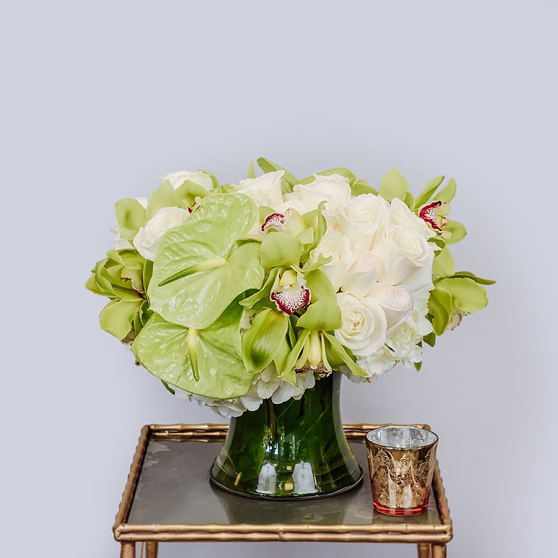 Lime Glow - The loveliest shade of green with high quality flowers. White Playa Blanca roses, green anthurium, green cymbidium orchids &amp; white hydrangeas in a clear cylinder lined with tea leaves.  