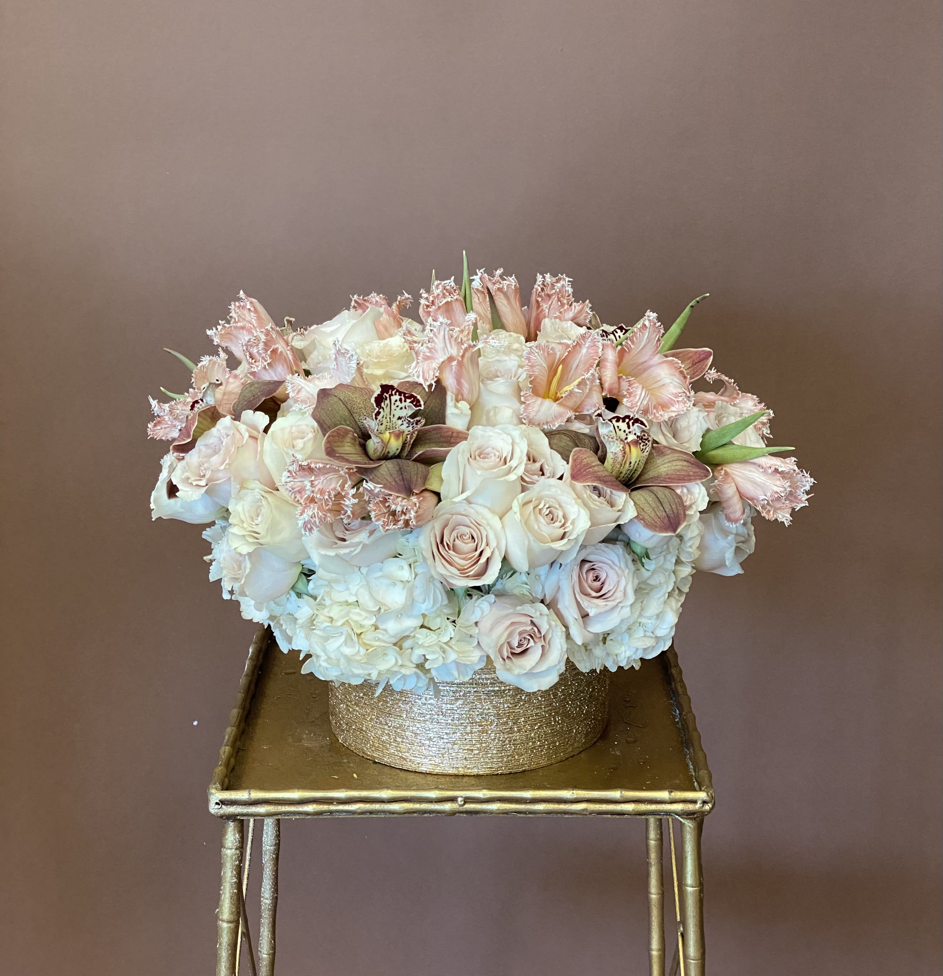 Just Picked - Just Picked serving us simple elegance. An effortless feel, but sure to wow with its lush look. The baby pink fringe tulips will steal the show and add an unique flair. Mixed with Cymbidium Orchids, Roses, and Hydrangea in a round, gold shimmery vase. 
