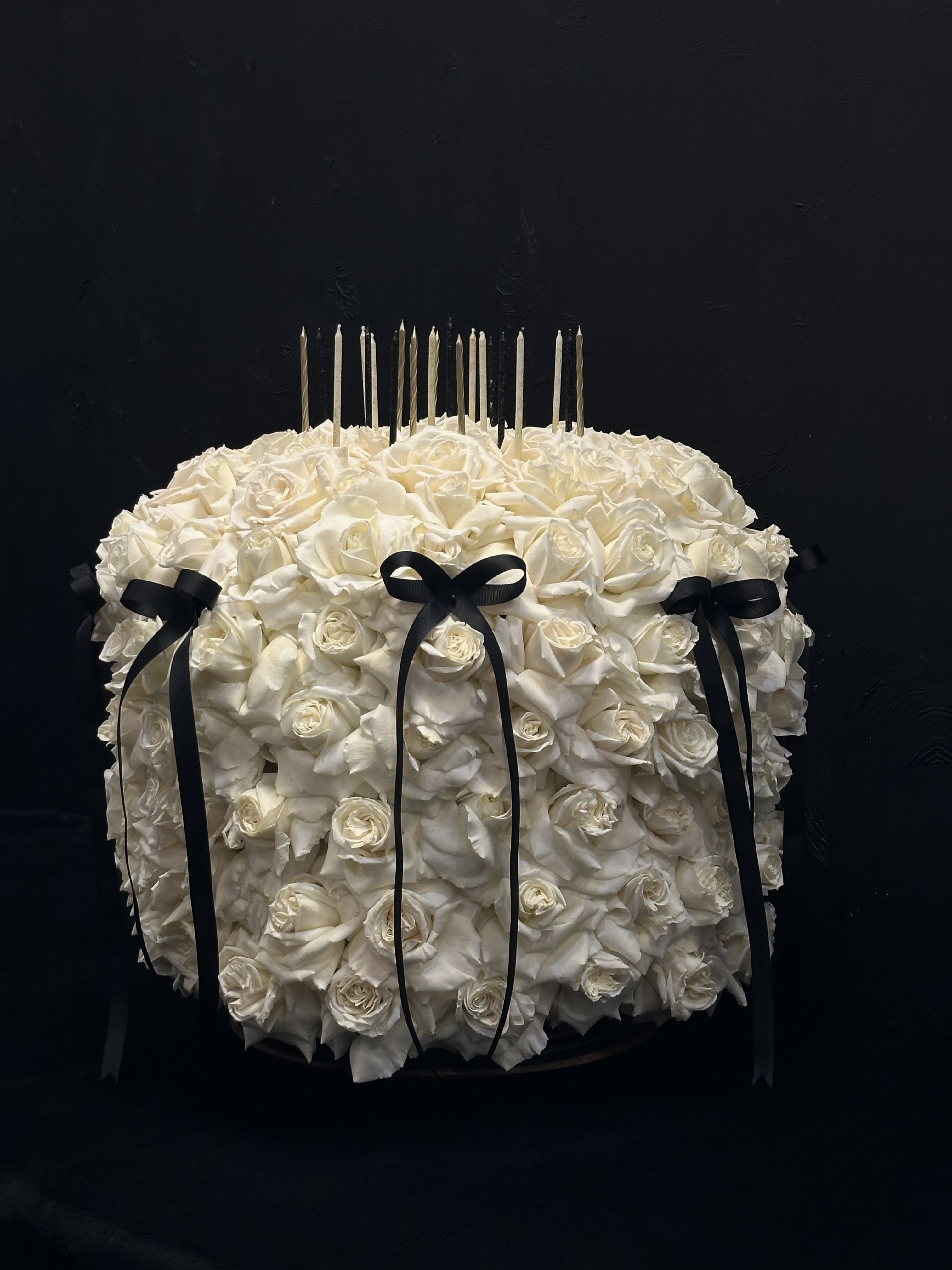 Birthday Cake  - This elegant flower arrangement is crafted to resemble a beautiful birthday cake, featuring a stunning display of pure white roses. The soft, fragrant blooms create a classic and sophisticated look, perfect for celebrating someone special.