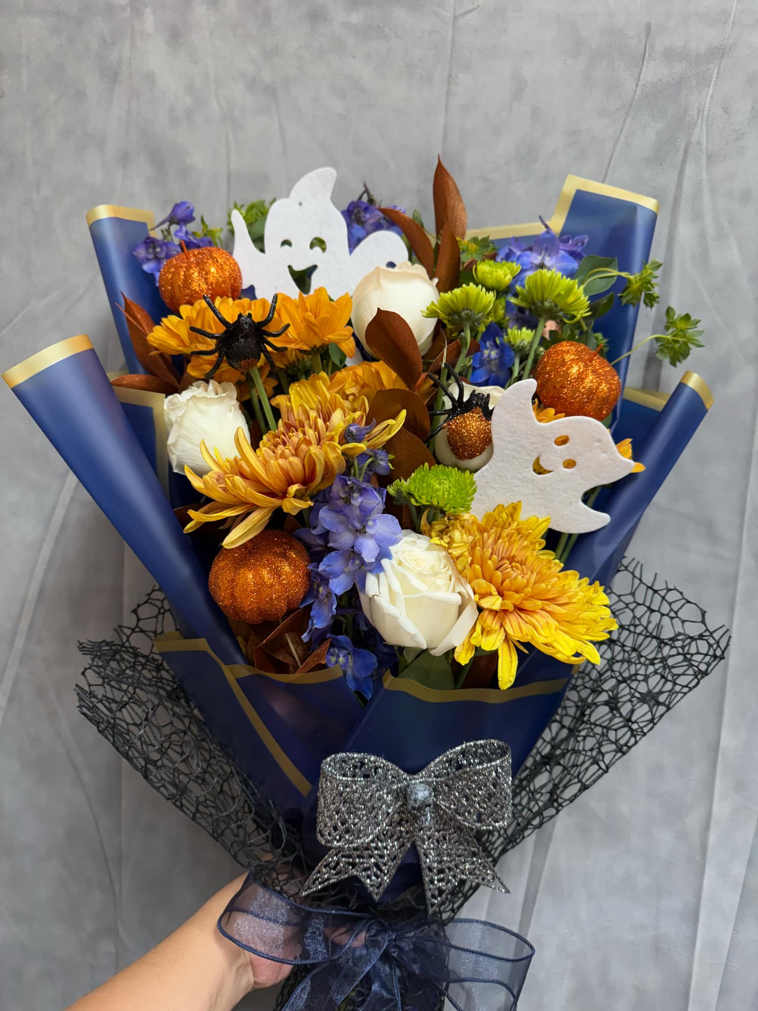 Ghostly Blooms Bouquet  Ghostly Blooms Bouquet  - Introducing our Ghostly Blooms Bouquet Design, a hauntingly beautiful mix of flowers and skeleton accents! Perfect for adding a spooky touch to your Halloween decor, this unique design captures the spirit of the season with charm and style. Don’t miss out on this festive creation!