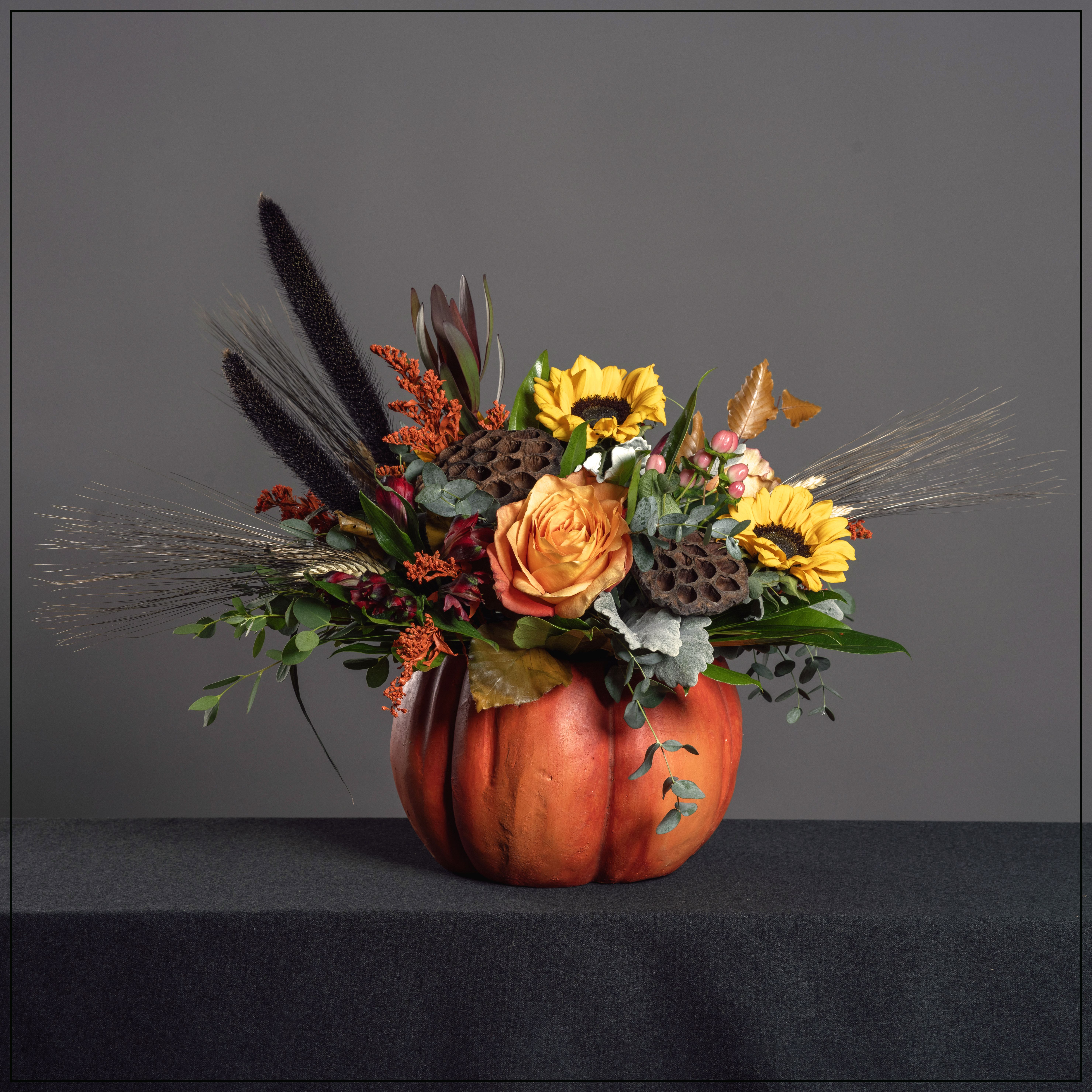 Rustic Garden Rustic Garden - Bursting from a ceramic pumpkin is an autumn mix of sunflowers, roses, safari sunset protea and alstroemeria lily along with dried lotus pods, wheat and preserved leaves. Dimensions: 18" H x 20" W