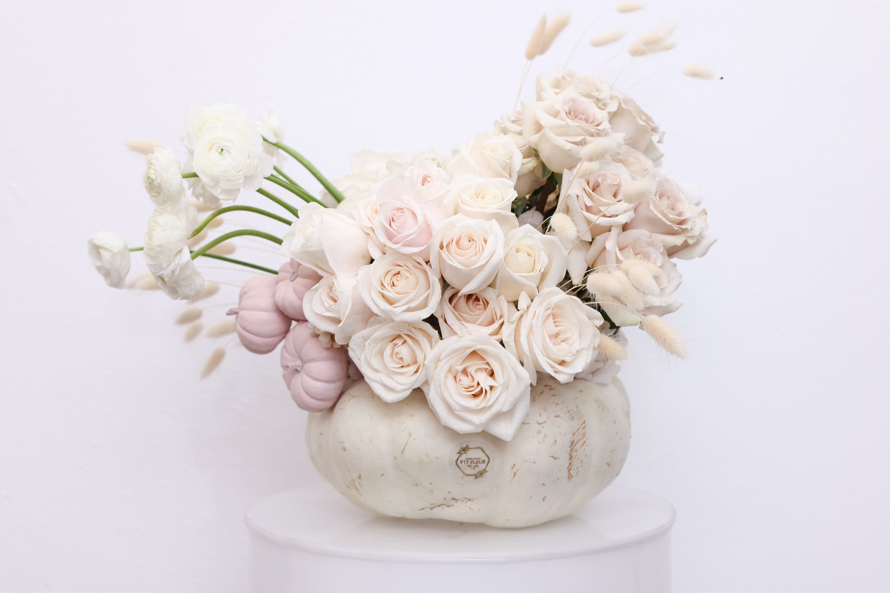 Mona - The arrangement comes in an organic white pumpkin with the following floral; Ranunculus, roses, preserved florals and small pumpkin decor. 