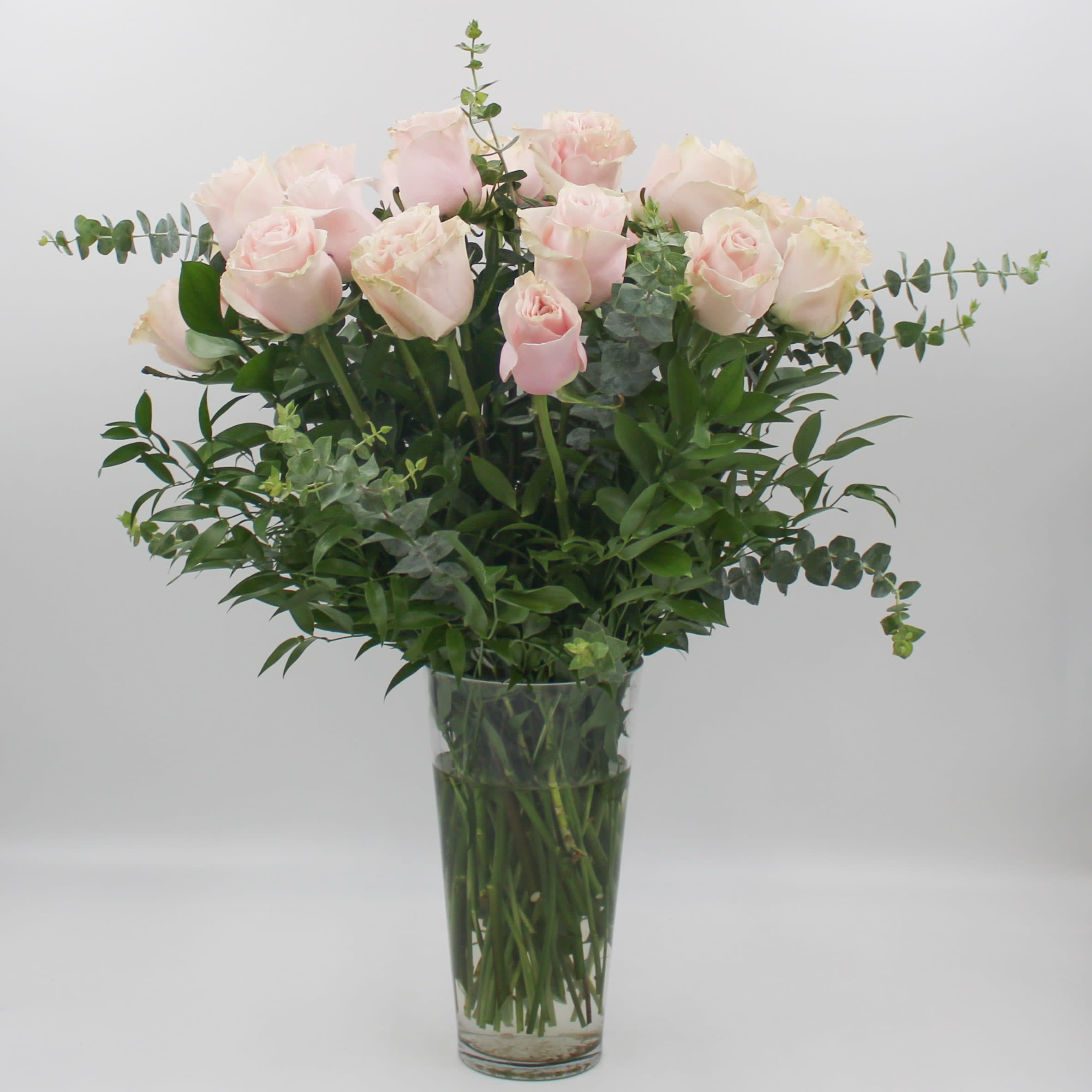 Two Dozen Pink - Two Dozen Ecuadorian Long Stem Pink Roses with Ruscus and Eucalyptus in a clear glass vase. 
