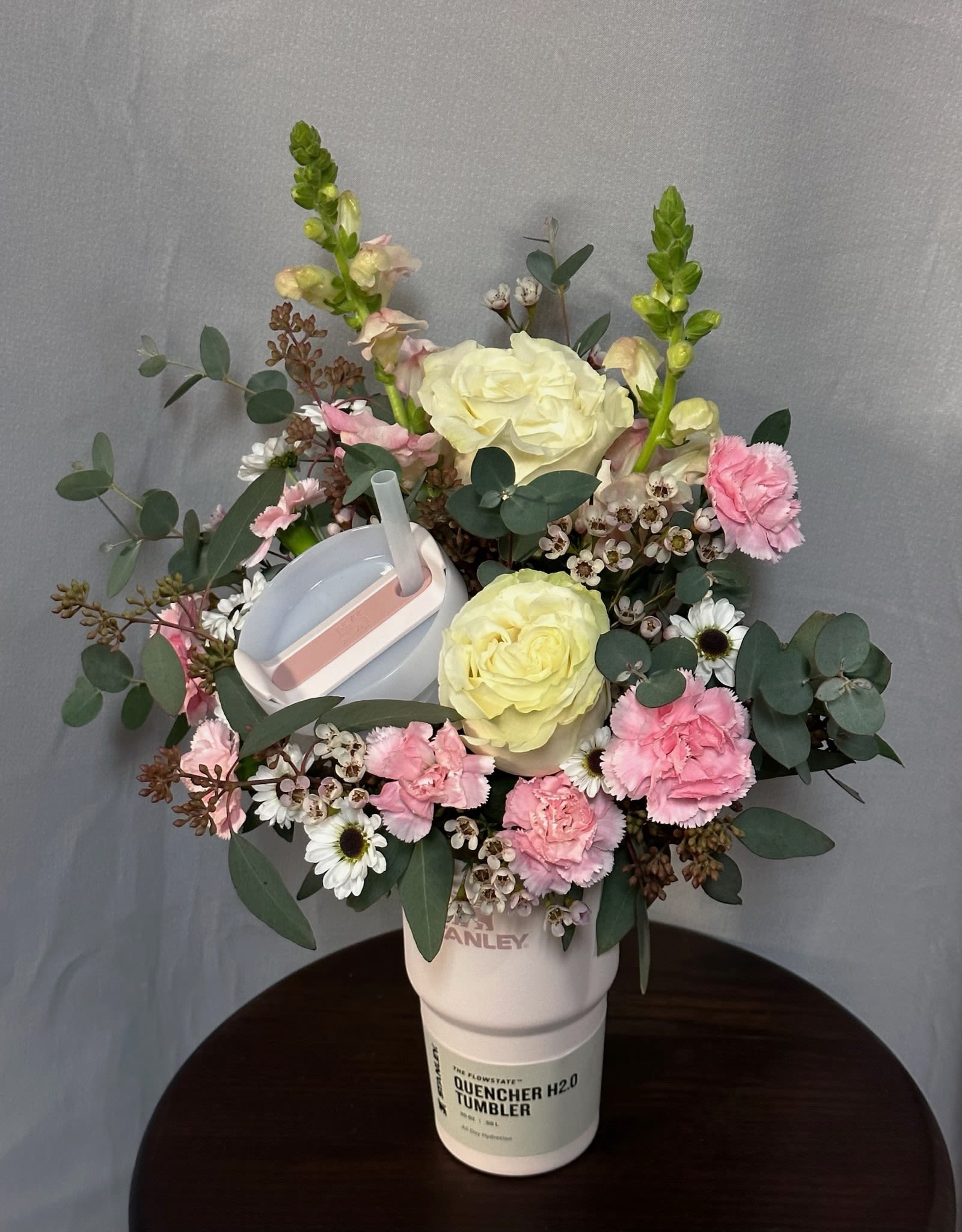 Stanley Cup Flower Arrangement  Stanley Cup Flower Arrangement  - This is the ultimate 2-in-1 gift! Available in 20 oz and 30 oz sizes, each arrangement features a beautiful mix of designer’s choice flowers, carefully selected for their seasonal charm. It’s the perfect combination of practicality and beauty, making it a thoughtful and versatile gift for any occasion.