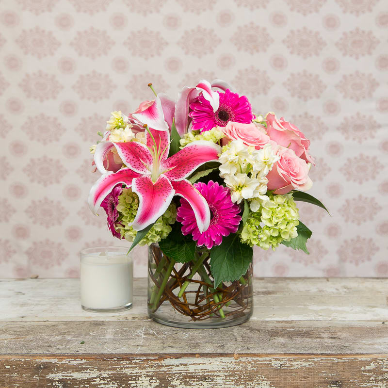 Pink Passion  - Perfect for a desk, small space or a little pick me up on the kitchen table, this arrangement is sassy addition! Packed with amazing smelling lilies and roses, accented with beautiful willow weaving in the vase. 