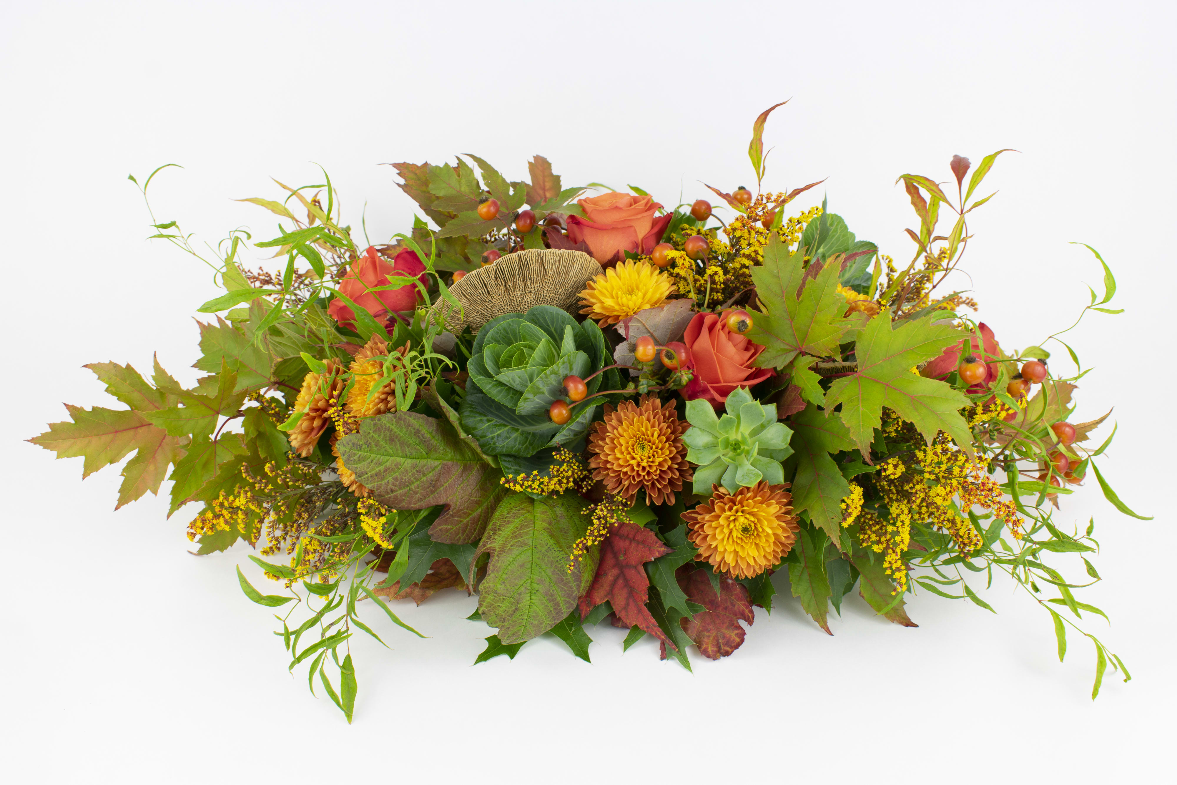 Thanksgiving Centerpiece - WOODLAND-INSPIRED THANKSGIVING FLOWER ARRANGEMENT  Warm and inviting. This lush Thanksgiving flower arrangement features a leafy blend of maple, viburnum and oak leaves with accents of orange blooms and red berries.  The design is carefree and wild, combining sculptural succulents, luscious roses, golden solidago, orange pom poms, rose hip, ornamental kale and decorative mushrooms. It’s perfect for bringing a festive ‘woodland’ vibe to your dining table or displaying on a mantlepiece or entrance table.  This gift will bring joy and beauty to anyone’s home over the festive season, whether it’s for yourself or someone dear to you.  Why not add a greeting card or quality handmade candle for an extra special Thanksgiving gift?  Thanksgiving Centerpiece features: -Maple leaves -Oak leaves -Viburnum leaves -Ornamental kale -Orange pom poms -Orange Crush roses -Sculptural succulents -Orange solidago -Decorative mushrooms -Rose hip