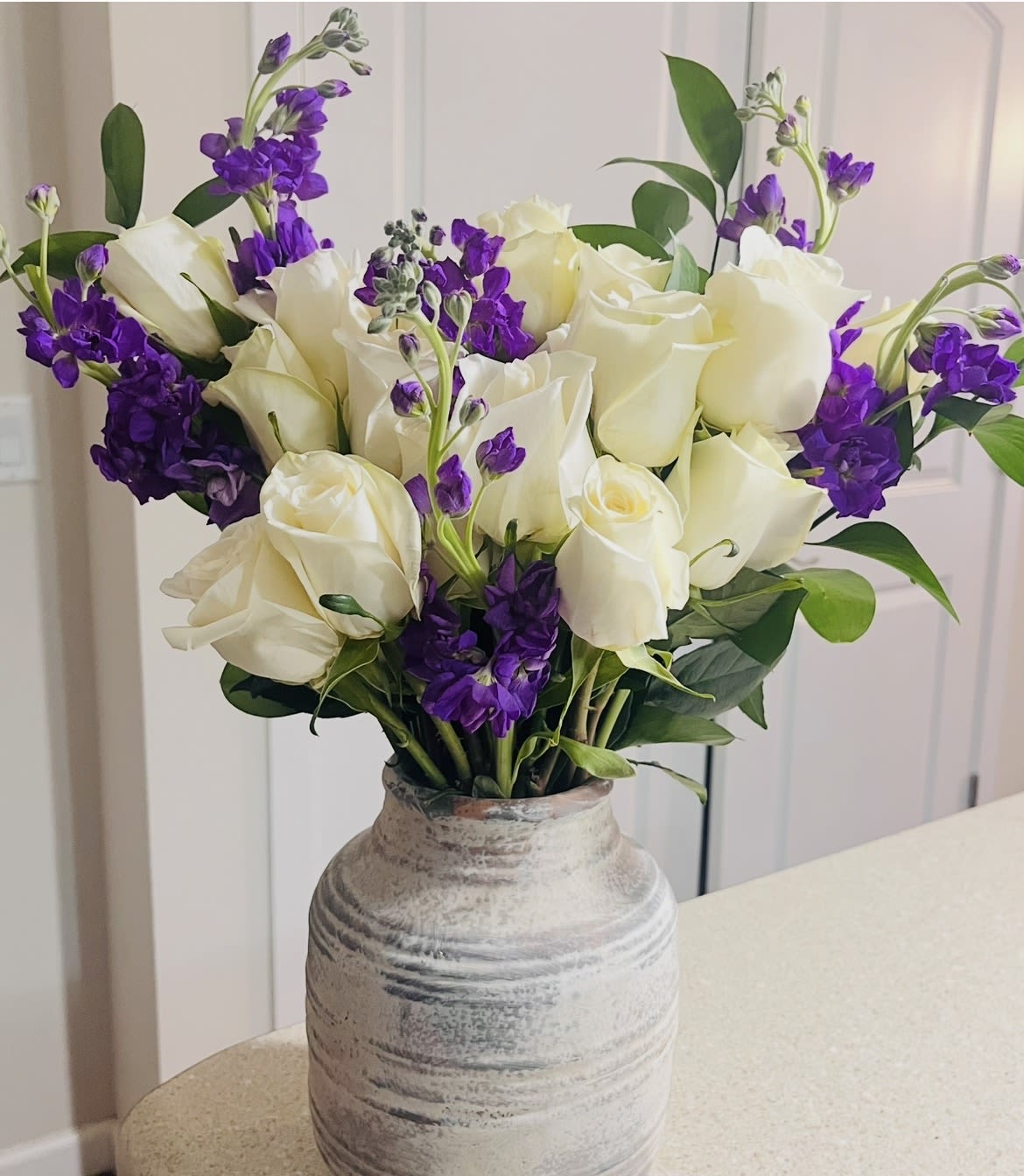 Elegant Contrast by Shelly's Floral - Sophisticated and striking, this design blends soft neutrals with vibrant tones to create a statement of pure elegance. Arranged in a handcrafted ceramic-style vase, it radiates timeless beauty and modern charm. Perfect as a centerpiece or a heartfelt gift, this arrangement brings refinement and warmth to any setting.  Whether you’re celebrating love, honoring a special occasion, or simply elevating a space, the Elegant Contrast Vase is designed to leave a lasting impression. 