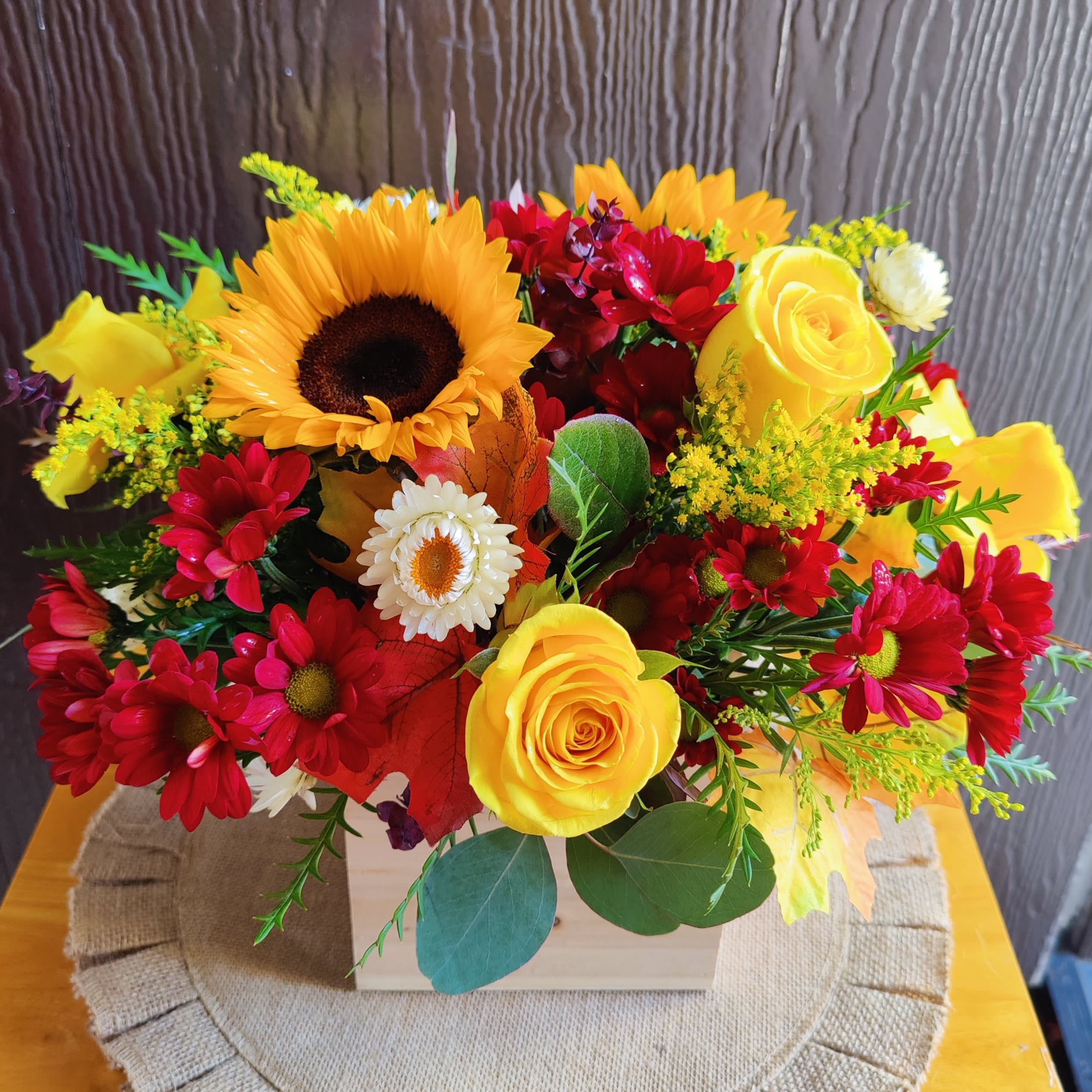 &quot; Autumn Moments &quot; Arrangement  - Autumn at home. Beautiful floral arrangement decorated with seasonal premium flowers in autumn colors. It includes Brighton roses, sunflowers, seasonal pompom flowers,  strawflowers, sunny solidago, and a mix of different fresh foliages. It includes a rustic wood container. Size is medium round style. Some flowers migh vary depending on the availability, recipient always receives beautiful Blooms. 