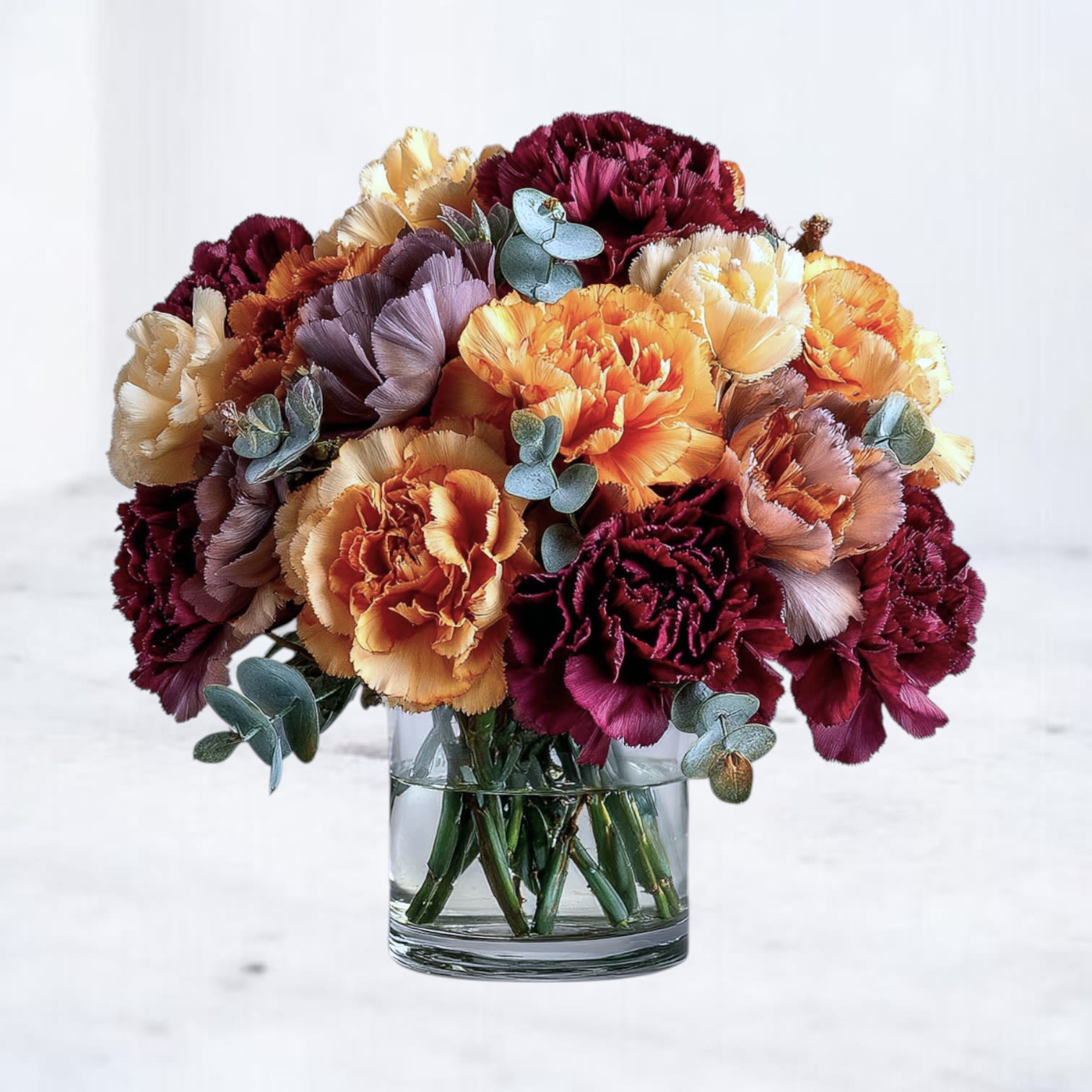 Fall Carns Bouquet Fall Carns Bouquet - Our Fall Carns Bouquet brings the warm glow of fall indoors with a lush mix of rich burgundy, burnt orange, and golden yellow carnations accented with fresh eucalyptus. Perfect for birthdays, seasonal décor, or sending love “just because,” this vibrant floral arrangement is designed in a modern glass vase for a timeless yet contemporary look. Whether you’re celebrating a special occasion or brightening someone’s day, this bouquet captures the fiery beauty of autumn with elegance and charm. Available for same-day flower delivery in Houston, Magnolia, The Woodlands, Spring, Tomball, and surrounding areas, the Fall Carns Bouquet is a customer favorite for both everyday gifting and seasonal celebrations.