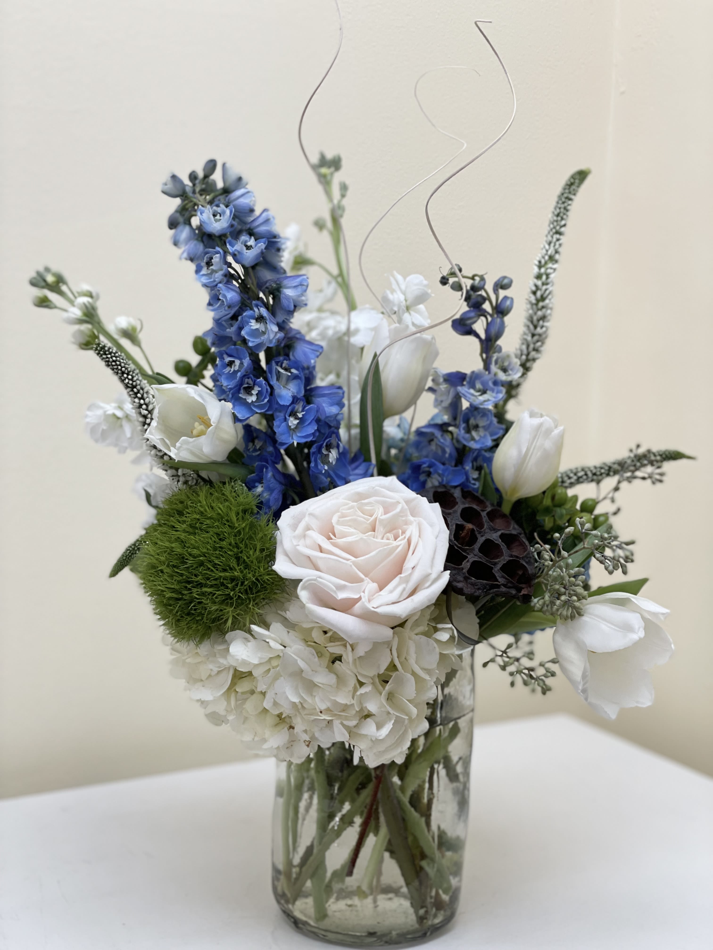 Blue and White. - A refreshing blue and white arrangement with elegant greens and additional textural elements.Vase measurement 31/2 by 6
