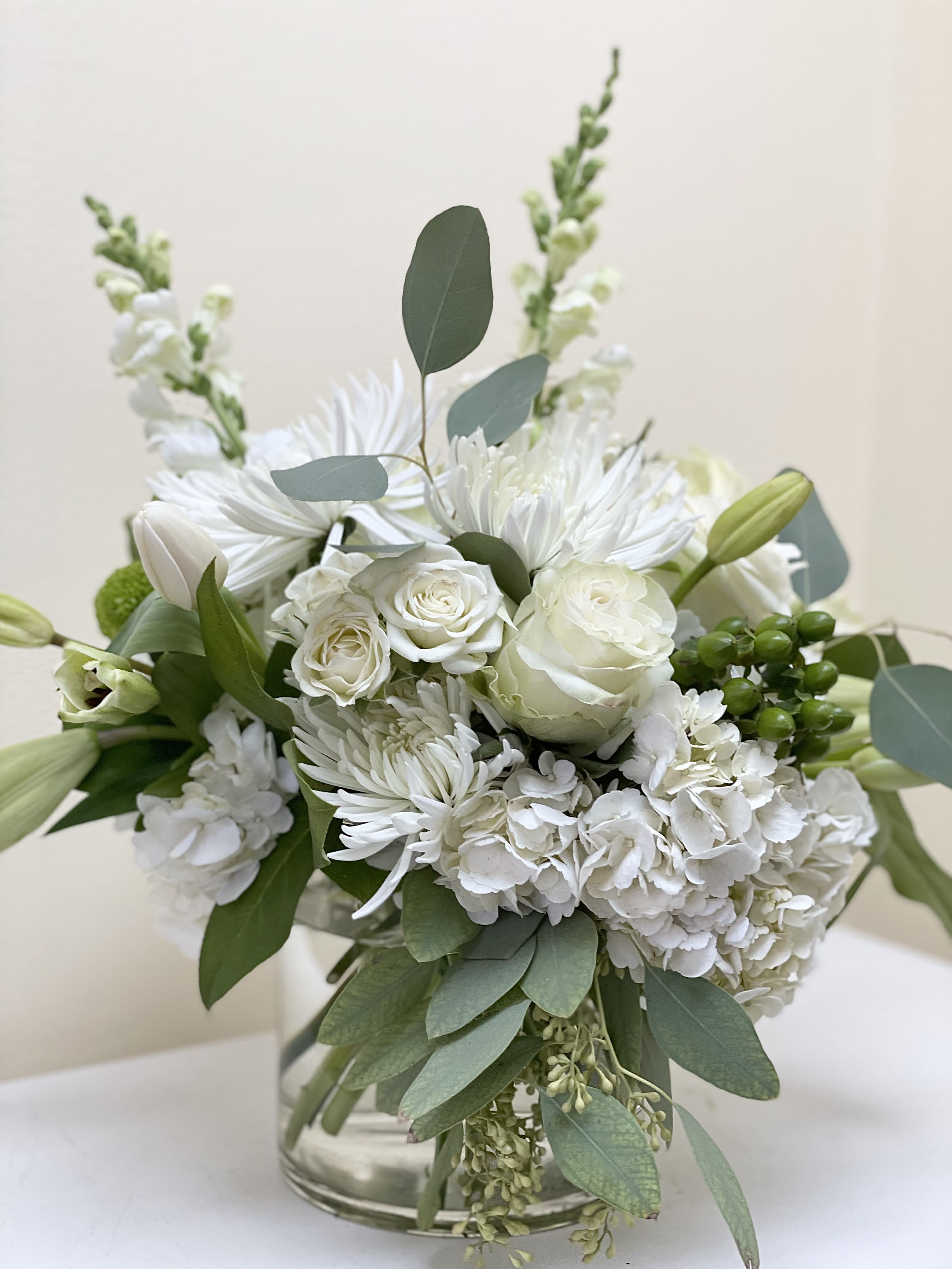 Monochromatic - A custom design with a lovely combination of white blooms and a variety of greens.Arrangement will reflect the picture but blooms and greens  may change with the season.