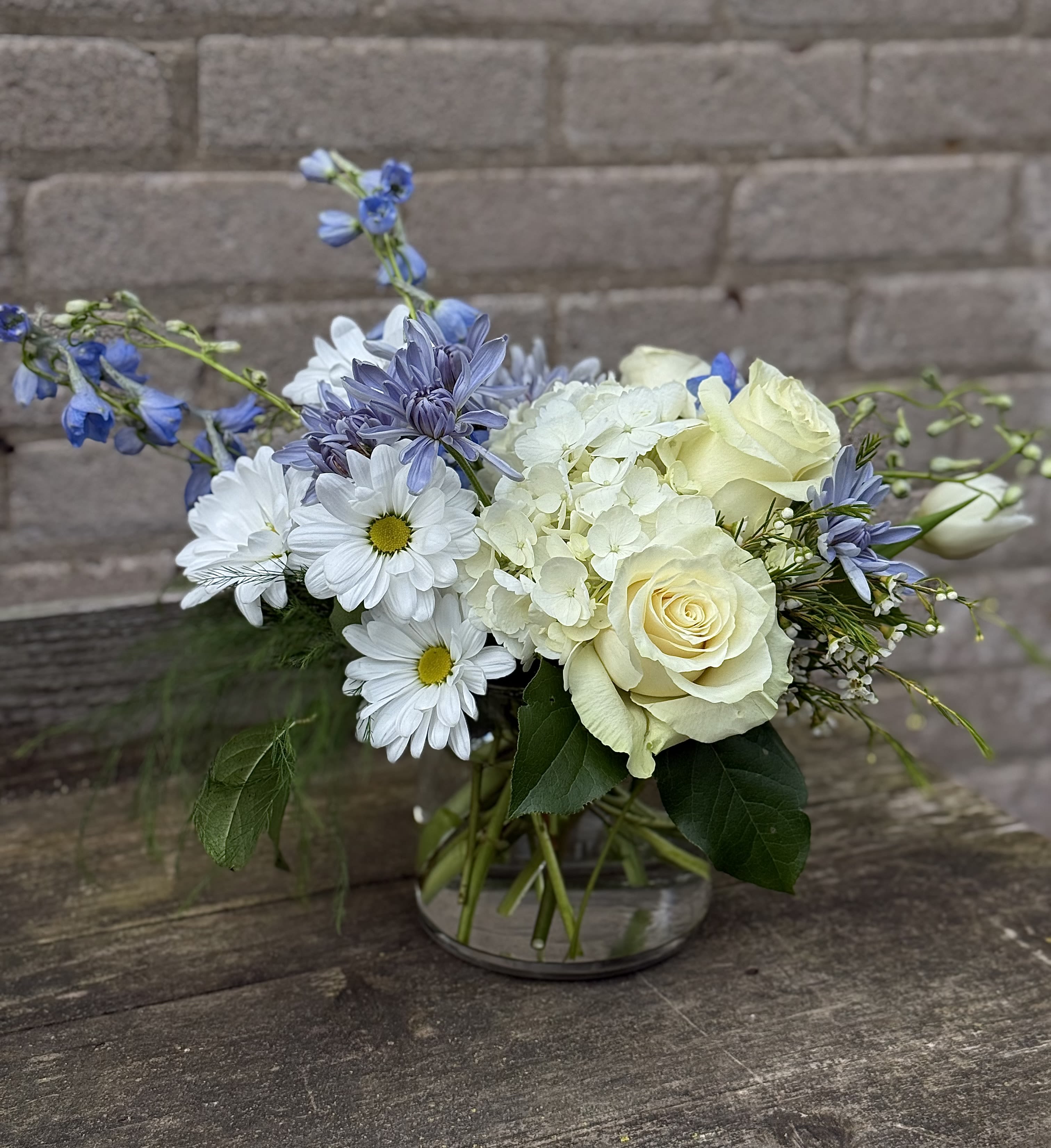 Mix of White and Blue - A lovely White and Blue design, fresh and modern with interesting blooms and textural greens, the blooms may change but we will come as close to the photo as possible