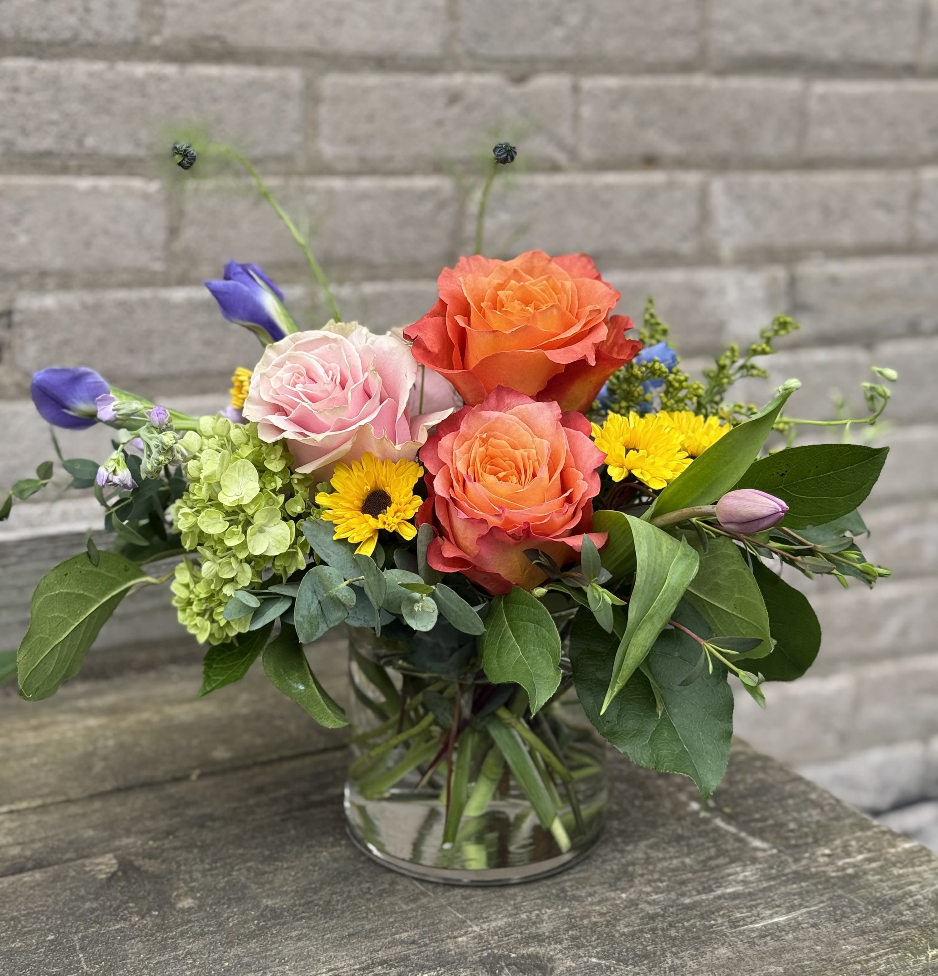 Summer Smiles - A beautifully designed arrangement with bright, vibrant colors and interesting greens, perfect for a desk, small table or side table, arrangement will be as close to photo as possible but blooms may change.