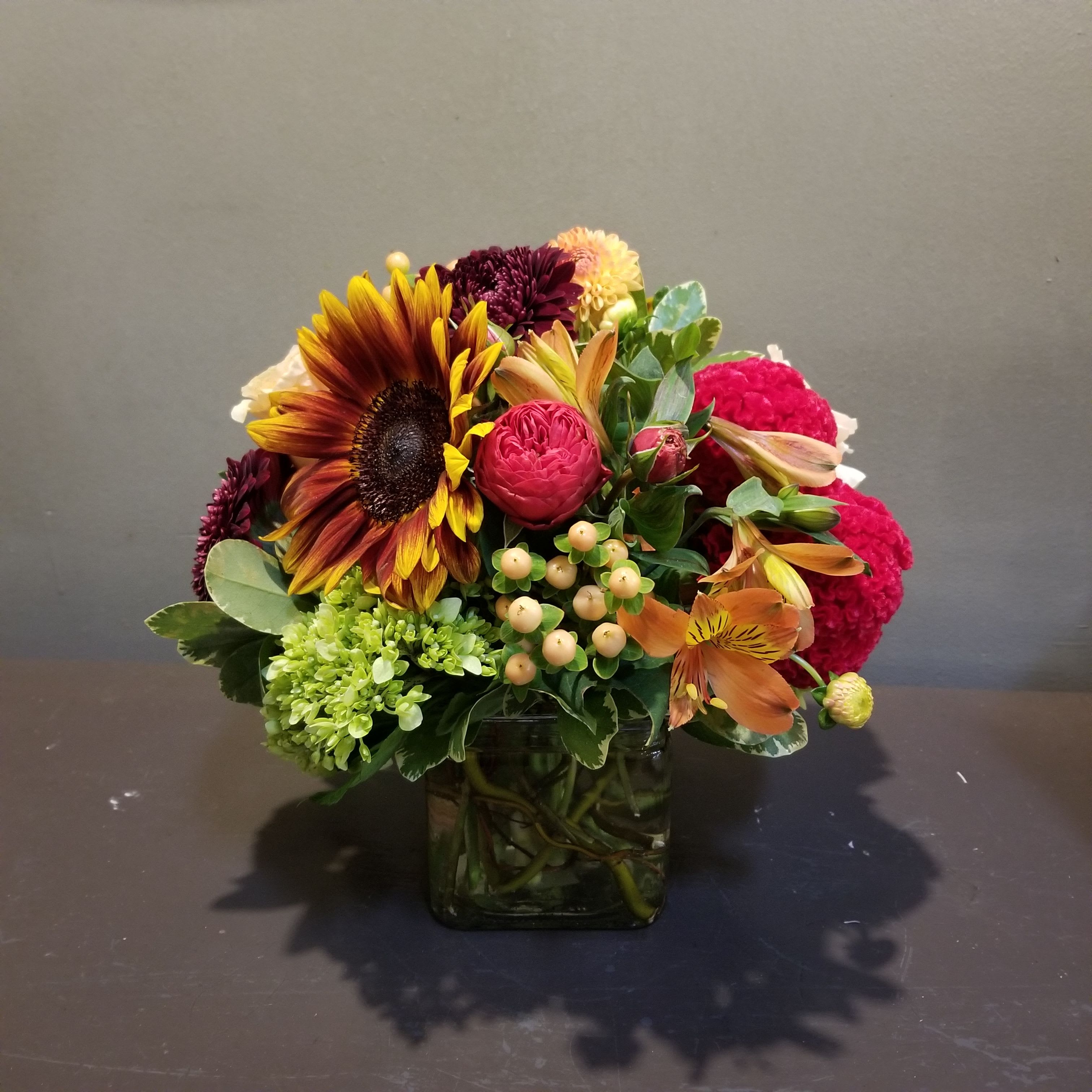 Sunset Vibes Sunset Vibes - Wish anyone a happy day with this autumn bouquet. Measures approx. 11" tall x 10" diameter and arrives in a glass cube vase.