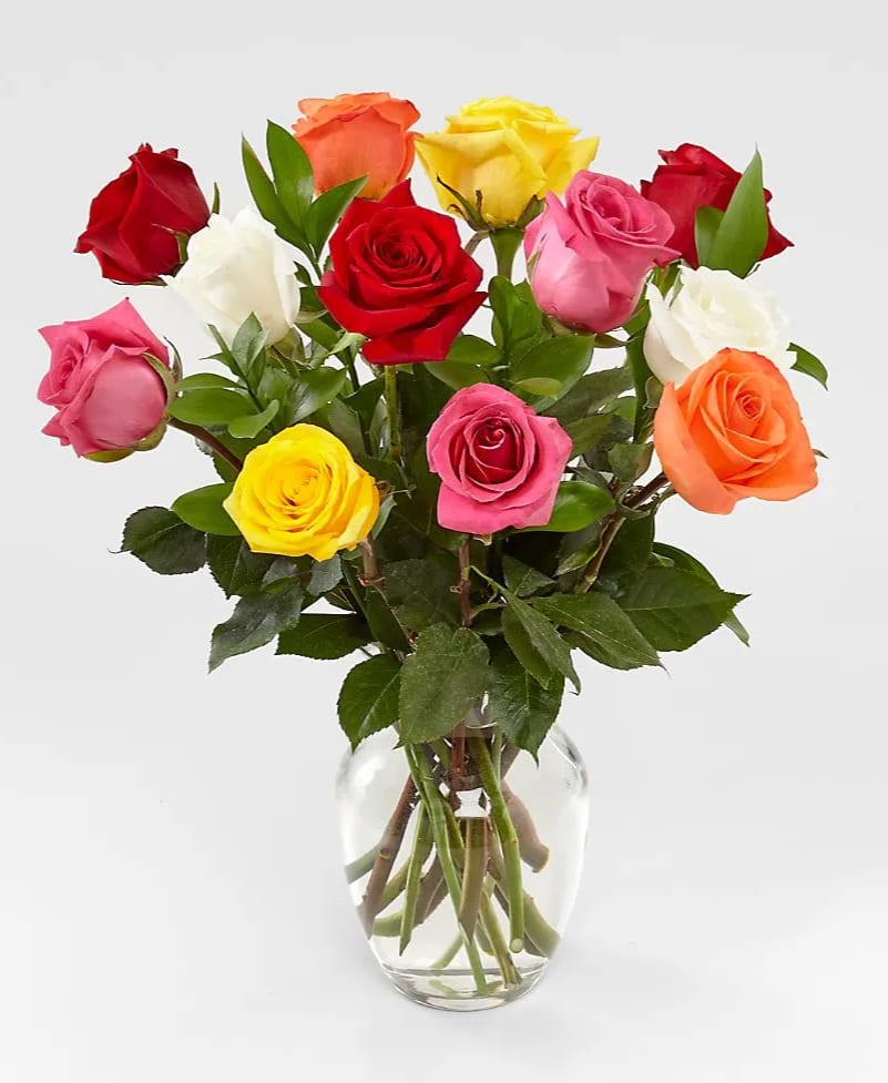 Rainbow Roses Rainbow Roses - Dozen mixed colored roses arranged in a cut glass vase with a variety of greens and filler flowers.