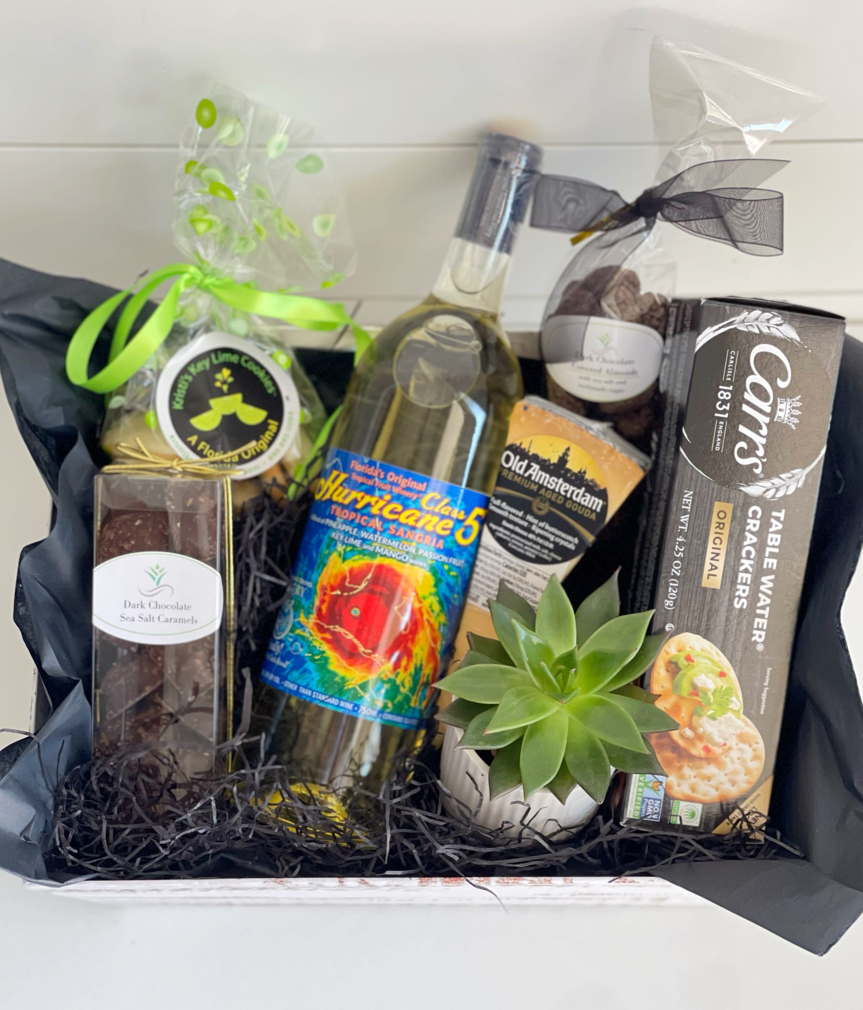 Gourmet Food and Wine - Gourmet Food and Wine Gift Basket: - bottle of Florida Original Tropical Sangria Wine - crackers - cheese  1/4 lb bag of Kristi’s Key Lime Cookies (featured in the Daytime EMMY® Awards Swag Bags in Hollywood CA and the News &amp; Documentary Emmy® Award Swag Bags in New York City) - Dark chocolate sea salt caramels  - dark chocolate covered almonds with sea salt and turbinado sugar - air plant or succulent in a small pot.