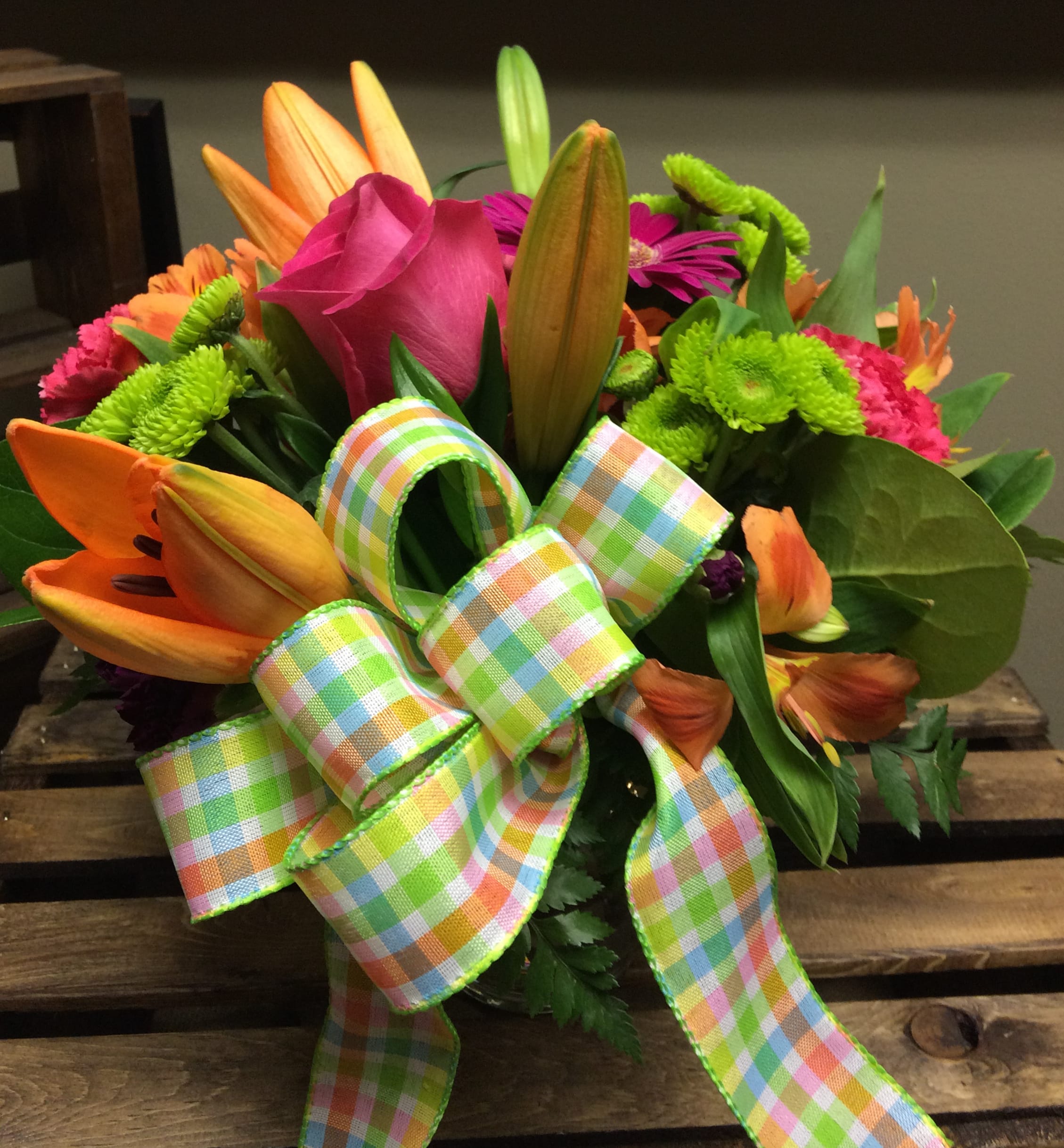 Spring is in The Air Custom Design by Cold Spring Floral - Spring is in The Air contains Orange Asiatic Lilies, Pink Roses, Green Kermit Button Mums, Hot Pink Carnations and Gerbera Daisies expertly designed for you in a Vase with Mixed Greenery.