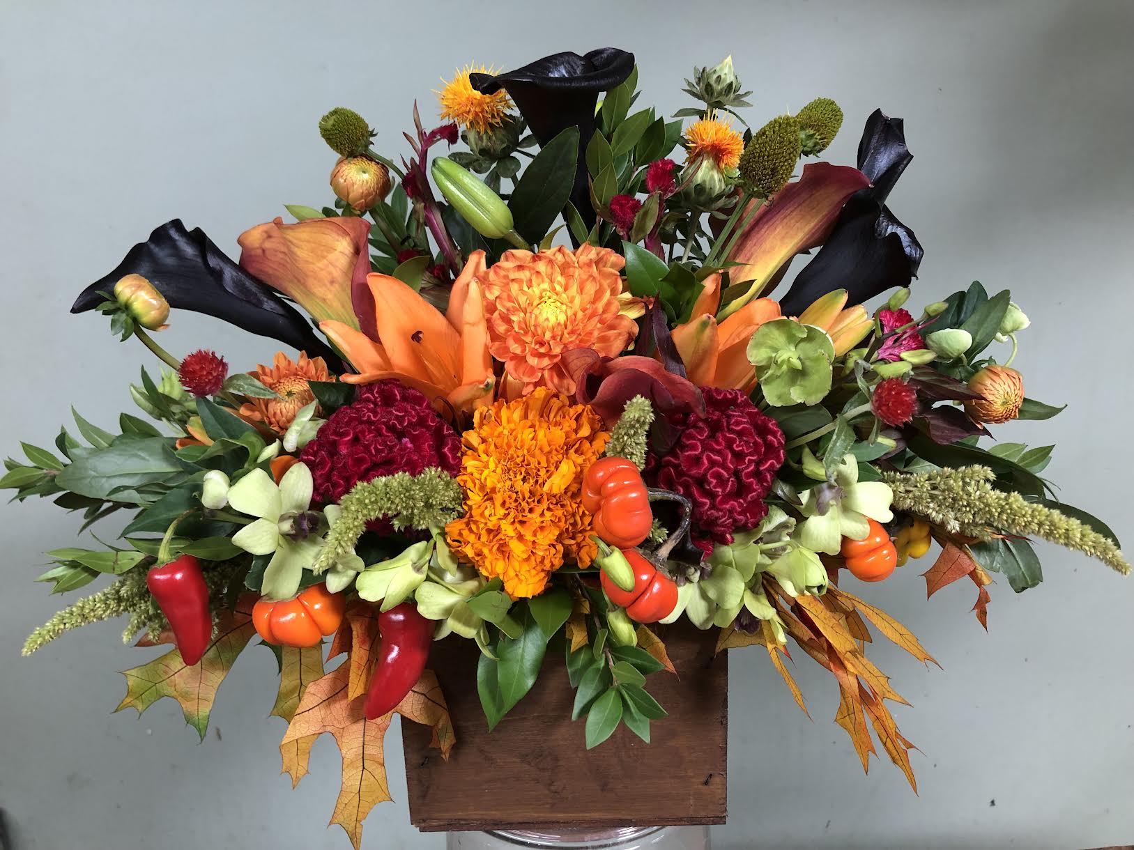 Blooming Autumn Blooming Autumn - Calla lilies, Orchids, Coxcombs, tiger lilies, Dahlias, Peppers and other wild flowers all hand arranged in wooden brown box.
