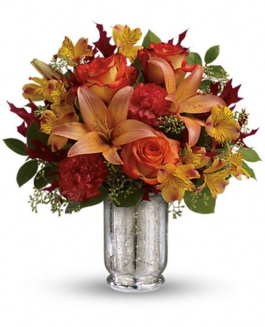Teleflora's Fall Blush Bouquet Teleflora's Fall Blush Bouquet - This fall, make that special someone blush with joy! Gorgeous bi-color roses and lilies brighten their day, while the magnificent mercury glass hurricane vase is a sparkling gift they'll always cherish. Stunning orange bi-color roses are arranged with orange asiatic lilies, yellow alstroemeria, dark orange carnations, seeded eucalyptus, lemon leaf and oak leaves. Delivered in an exclusive silver Mercury Glass hurricane. Approximately 15" W x 15 1/2" H TFL08-1A