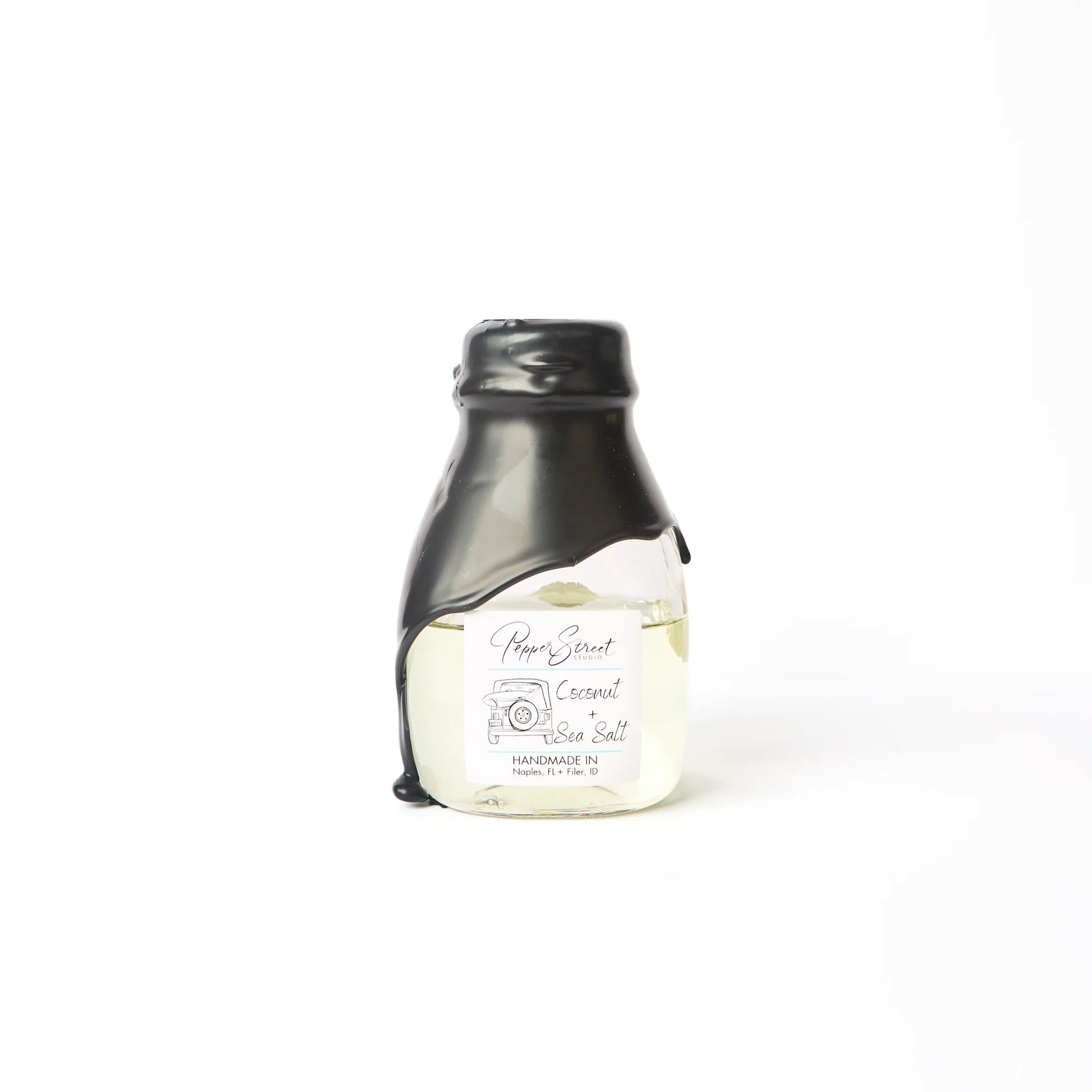 COCONUT + SEA SALT LARGE ROOM DIFFUSER COCONUT + SEA SALT LARGE ROOM DIFFUSER - Pepper Street's signature black wax hand-dipped room diffuser is in a short milk glass bottle. It includes ten bamboo reeds and a wood flower for a sweet touch and effective scent diffusion. The best part? Their diffuser oils are wholly toxin-free and contain no additional alcohol, ensuring a long-lasting scent that will last you longer than a year. A pull tab on the back allows easy access to the lid. Weight: 9 fl oz | 266 ml Coconut + Sea Salt Experience a tropical paradise's rejuvenating and calming essence with the coconut and sea salt scent. The sweet and creamy notes of coconut harmoniously blend with the salty and briny scent of sea salt, transporting you to the beach. This refreshing and invigorating aroma is perfect for unwinding after a long day or during a spa day, leaving you feeling refreshed and relaxed. Indulge in the soothing fragrance and let it rejuvenate your mind and body. Linen gift bag included.