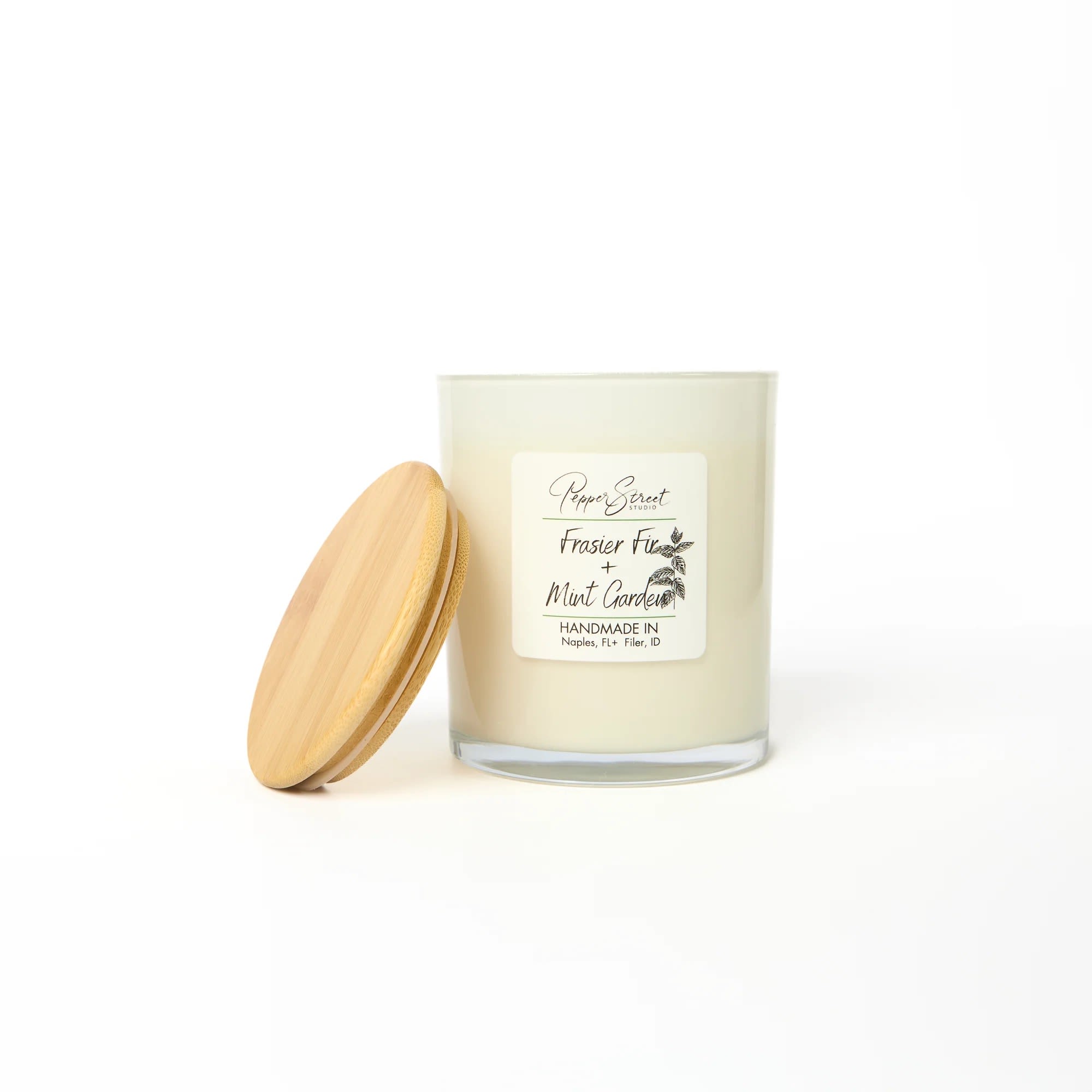 FRASIER FIR + GARDEN MINT CANDLE FRASIER FIR + GARDEN MINT CANDLE - Experience eco-conscious luxury with Pepper Street's 13-ounce soy wax candle. Crafted with toxin-free fragrances, it provides a clean, safe burn. The wood wick adds natural elegance and a subtle crackle for peacefulness and tranquility. Ideal for those who value high-quality, sustainable products. Burn time is 80+ hours. For best results, burn the candle for 2-3 hours until the wax melts evenly. Always trim the wick before lighting. Frasier Fir + Garden Mint Revitalize with the crisp aroma of fir needles, mint, citrus, and spice.