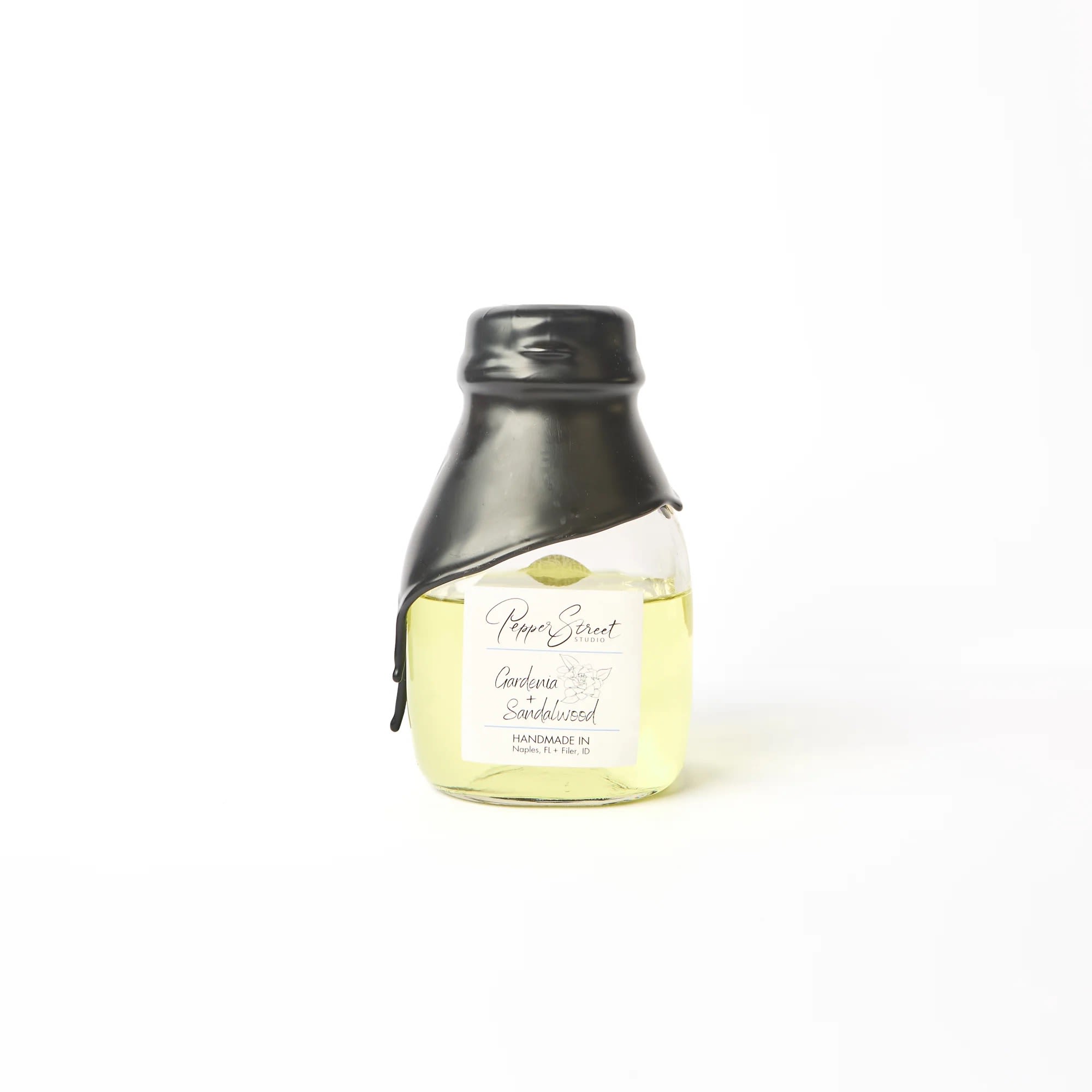 GARDENIA + SANDALWOOD LARGE ROOM DIFFUSER GARDENIA + SANDALWOOD LARGE ROOM DIFFUSER - Pepper Street's signature black wax hand-dipped room diffuser is in a short milk glass bottle. It includes ten bamboo reeds for a sweet touch and effective scent diffusion. The best part? Their diffuser oils are wholly toxin-free and contain no additional alcohol, ensuring a long-lasting scent that will last you longer than a year. A pull tab on the back allows easy access to the lid. Weight: 9 fl oz | 266 ml Gardenia + Sandalwood Experience the ultimate indulgence with our gardenia and sandalwood scent. The exquisite blend of these two fragrances creates a luxurious and calming atmosphere, perfect for unwinding after a long and tiring day. The gardenia notes are sweet and floral, providing a gentle and calming effect on the senses. At the same time, the sandalwood adds a touch of warmth and earthiness to the mix, promoting a serene environment. Linen gift bag included.