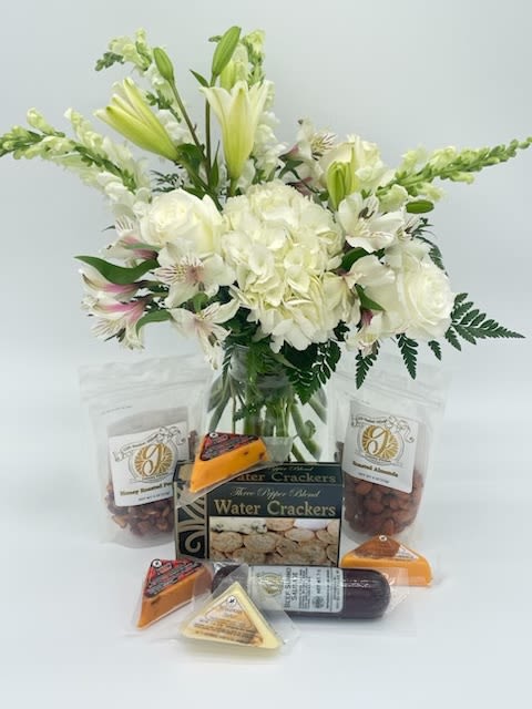 Elegant Gourmet & Blooms Gift Set Elegant Gourmet & Blooms Gift Set - A perfect blend of beauty and indulgence. This thoughtfully curated gift set pairs a lush arrangement of fresh white blooms — including lilies, roses, and alstroemeria — with a selection of gourmet treats. Crisp water crackers, rich artisan cheeses, savory summer sausage, and honey-roasted almonds create a delicious tasting experience to complement the floral elegance.