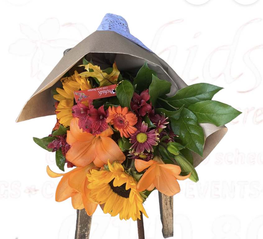 Autumn Lily Mix Wrapped Autumn Lily Mix Wrapped - Add the perfect touch of fall to your home with our autumn lily mix blooms, a bouquet with a wide variety of breathtaking fall tones. Bright orange lilies, sunflower, accented with red and orange blooms. Wrapped in gift wrap or Parchment Paper and dressed with ribbon.