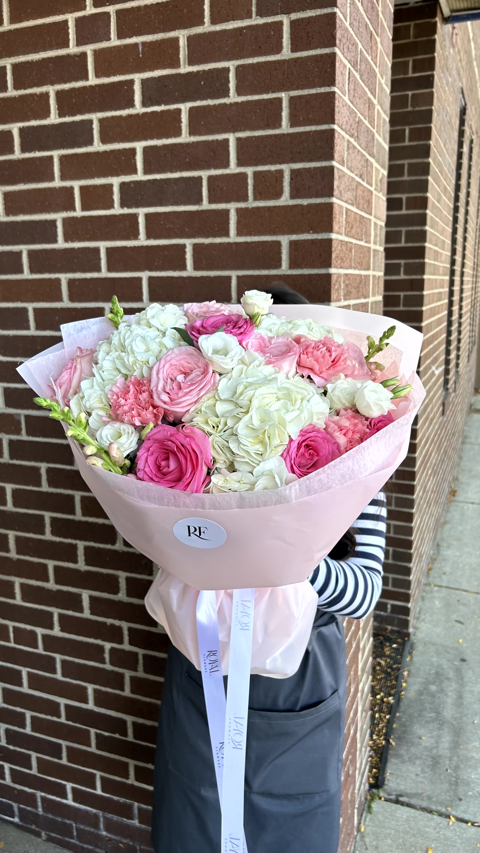 Serene Grace - A graceful combination of white hydrangeas, premium roses, stock flowers, and delicate light pink carnations for a touch of timeless elegance. 