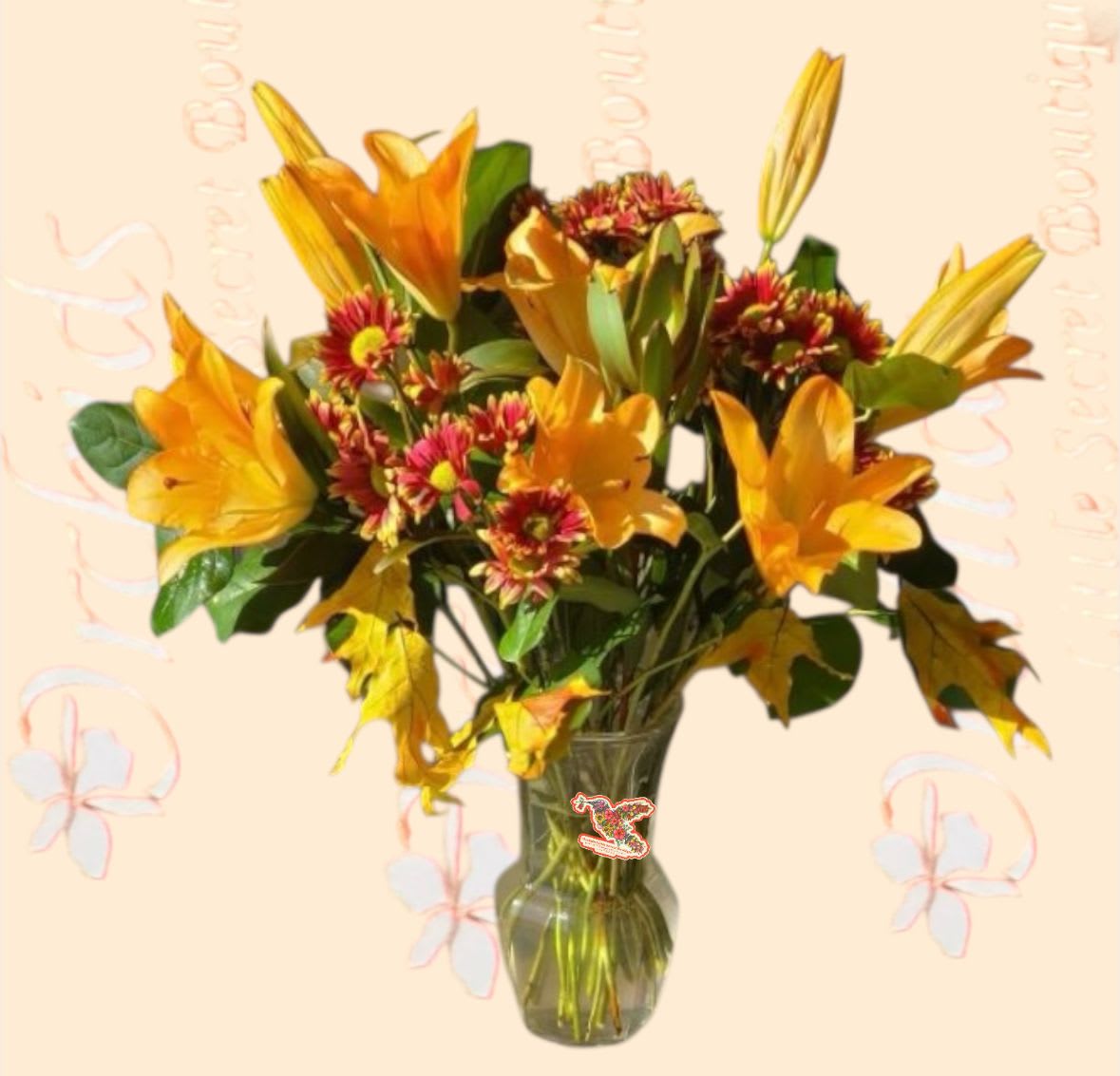 Lily  HarvestFall Bouquet   - Standard  arrangement measures approximately 14&quot;H  Deluxe arrangement measures approximately 18&quot;H Send fall vibrant colored flowers in honor of a fall birthday, to help you offer your sincerest wishes for comfort and peace during a difficult time, Thanksgiving, or as a way to express your thanks and gratitude throughout the season. Artistically designed in a clear glass vase accented with orange ribbon .  This arrangement is perfect for various occasions, offering warmth and beauty to any setting.