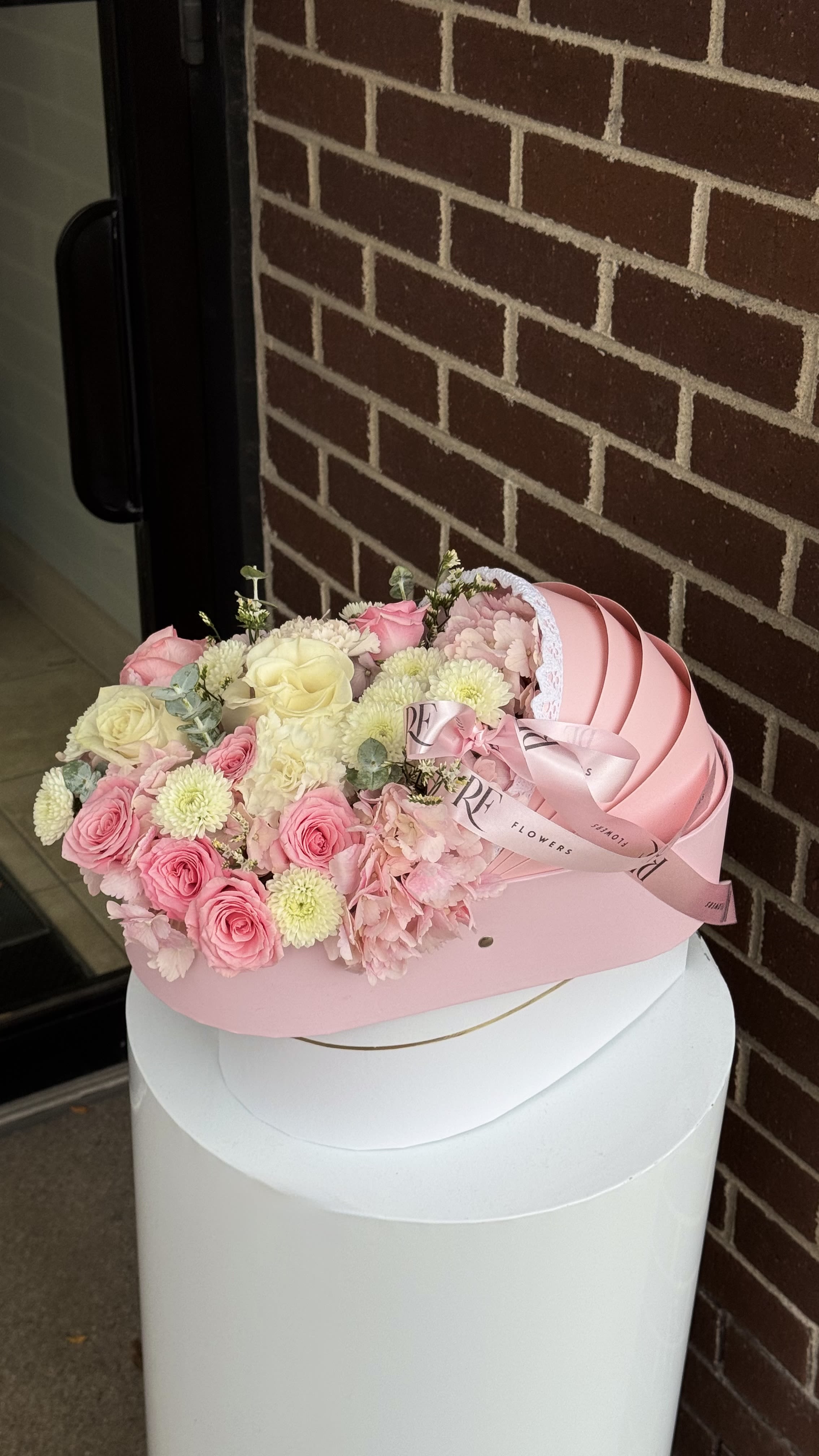 Pink Cradle - Welcome your little angel with our Baby Pink Cradle, a tender floral creation that celebrates new beginnings. Soft pink and white roses blend beautifully with fluffy hydrangeas, symbolizing love, innocence, and purity.