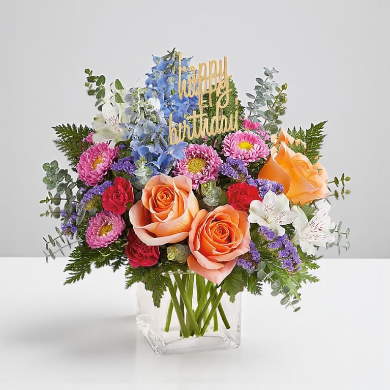 Birthday Bliss Bouquet - Make their special day unforgettable with our Birthday Bliss Bouquet — a vibrant mix of roses, carnations, alstroemeria, delphinium, and asters. Bursting with cheerful color and festive charm, this arrangement is designed to bring joy, smiles, and a touch of elegance to any birthday celebration.  Hand-arranged by our expert florists and delivered ready to display, it’s the perfect gift for birthdays of all ages.  Details:  Hand-designed by professional florists, arranged and ready to enjoy.  For longer-lasting beauty, refresh the water daily and trim stems every 2–3 days.  Pet safety note: Some flowers and foliage may be toxic to pets. Please keep out of reach.  Bloom Details:  Roses  Carnations  Alstroemeria  Delphinium  Asters