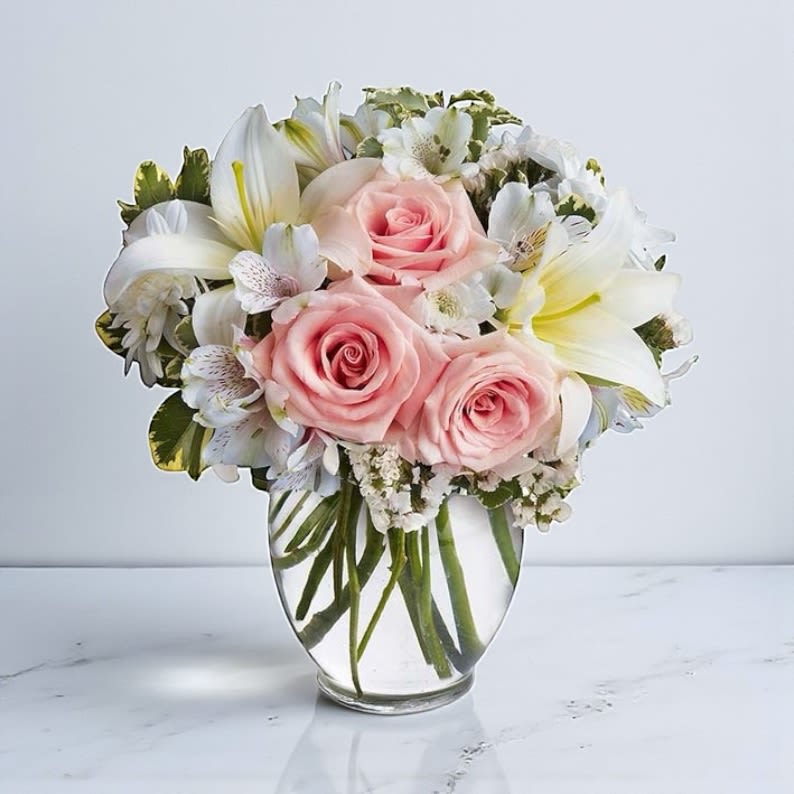 Arrive In Style Bouquet - Arrive in Style is a Stylish flower bouquet that will express your love with the eloquence of Shakespeare - without saying a word. She'll adore this exquisite bouquet of roses and lilies and other pastel favorites in a classic ginger vase. And she'll know just the words to let you know. Light pink roses, white asiatic lilies, white alstroemeria and white cushion spray chrysanthemums are mixed with white statice and variegated pittosporum in a clear, rounded vase.Orientation: All-Around  Includes: • Pink Roses • White Asiatic Lilies • Alstroemeria • White Cushion Spray Mums • White Statice • Floral Greens  Size:  Standard - 11&quot; H by 10 1/2&quot; W Deluxe - 12&quot; H by 11&quot; W Premium - 13&quot; H by 12&quot; W