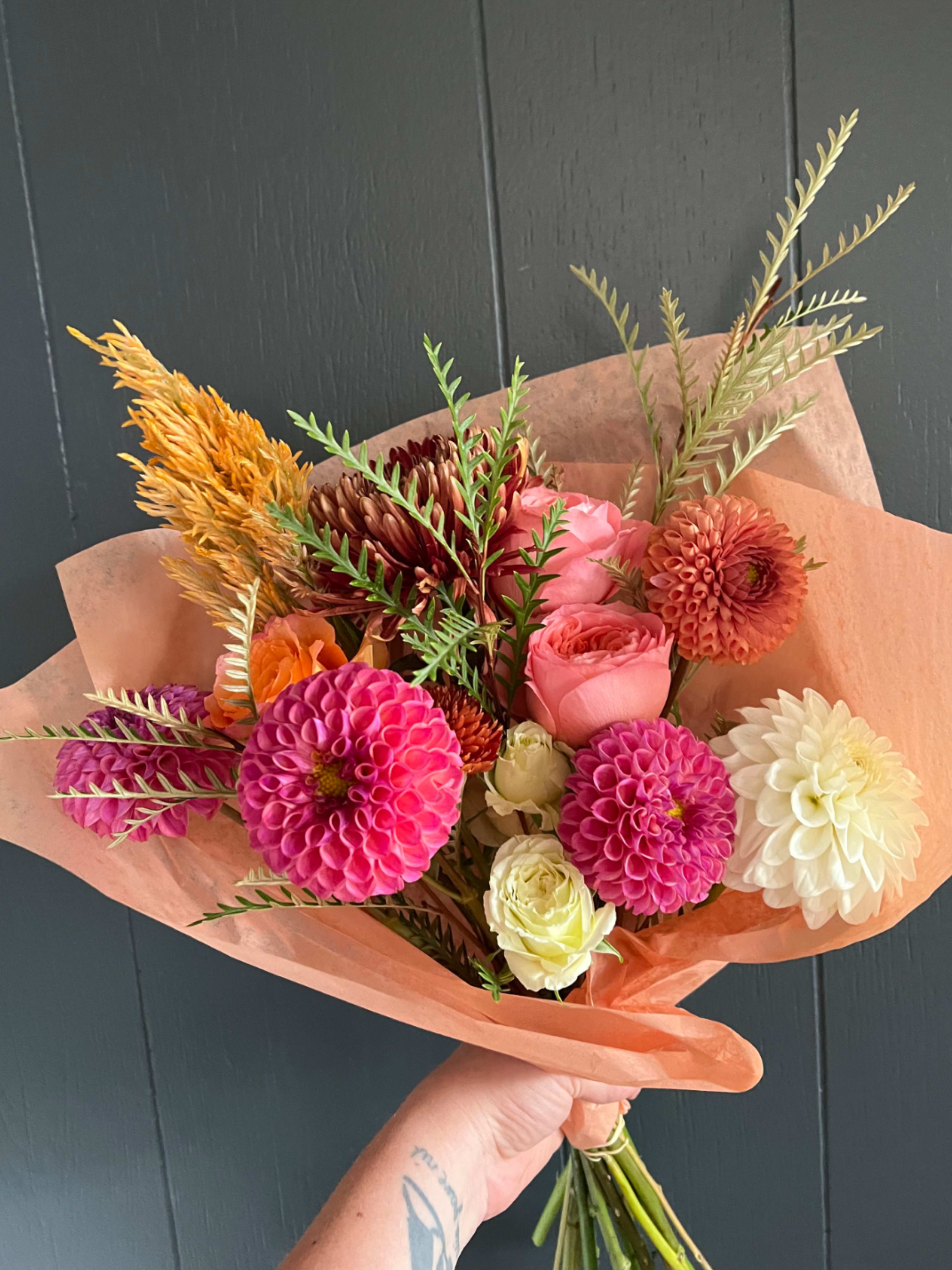SEASONAL WRAPPED BOUQUET - Seasonal, colorful flowers and foliage wrapped in floral paper. No vase included.  Year round flowers that we typically stock: specialty rose, spray rose and garden rose, ranunculus, anemone, gerbera daisy, protea, lisianthus, chrysanthemum, larkspur, snapdragon, delphinium, stock, aster, dianthus, hypericum, feverfew, astrantia, leucodendron