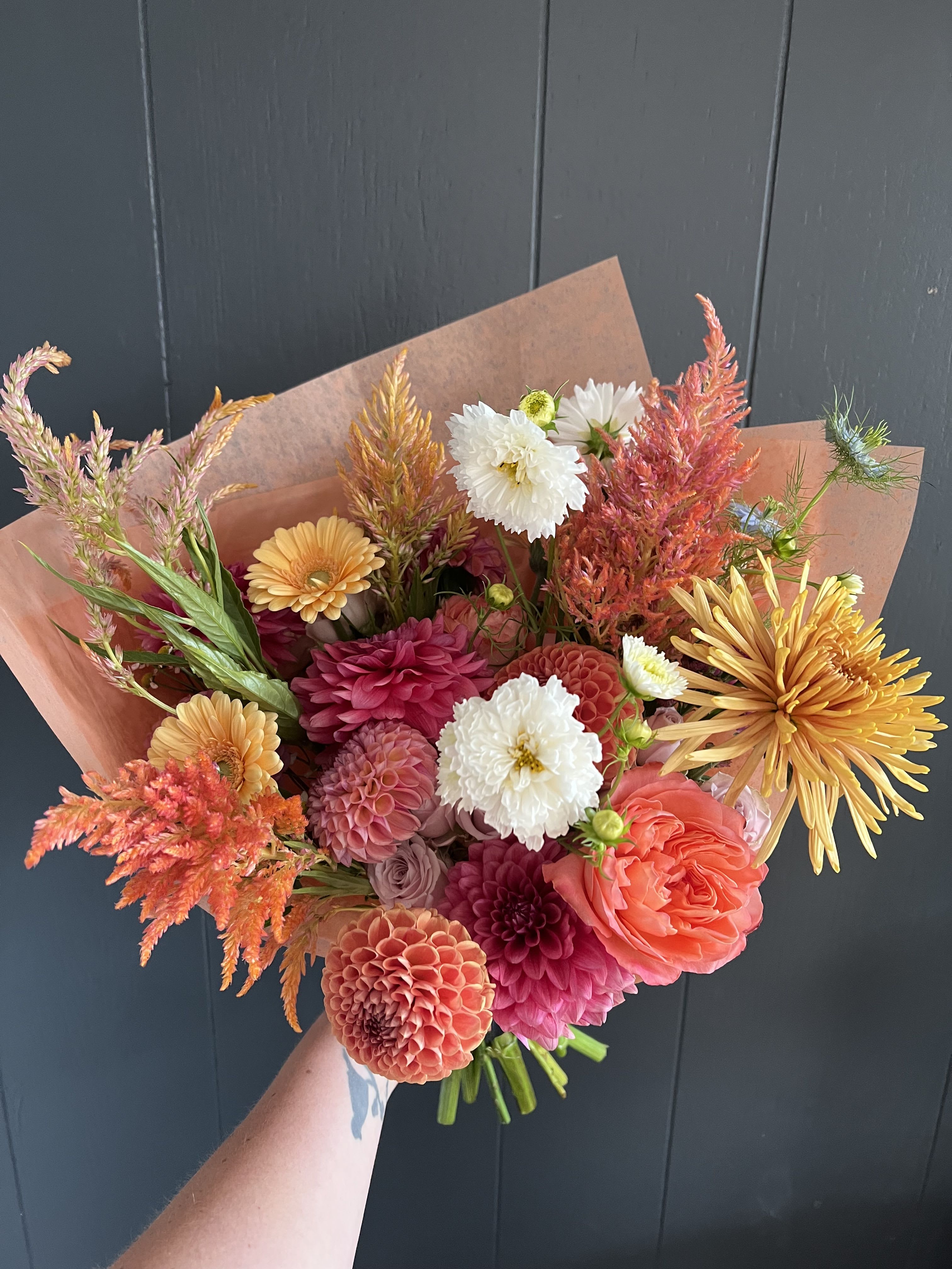 ARTFUL SEASONAL HAND-TIED BOUQUET - Seasonal, colorful flowers and foliage artfully arranged, wrapped in tissue and ready to drop in a vase at home.  Year round flowers that we typically stock: specialty rose, spray rose and garden rose, ranunculus, anemone, gerbera daisy, protea, lisianthus, chrysanthemum, larkspur, snapdragon, delphinium, stock, aster, dianthus, hypericum, feverfew, astrantia, leucodendron.