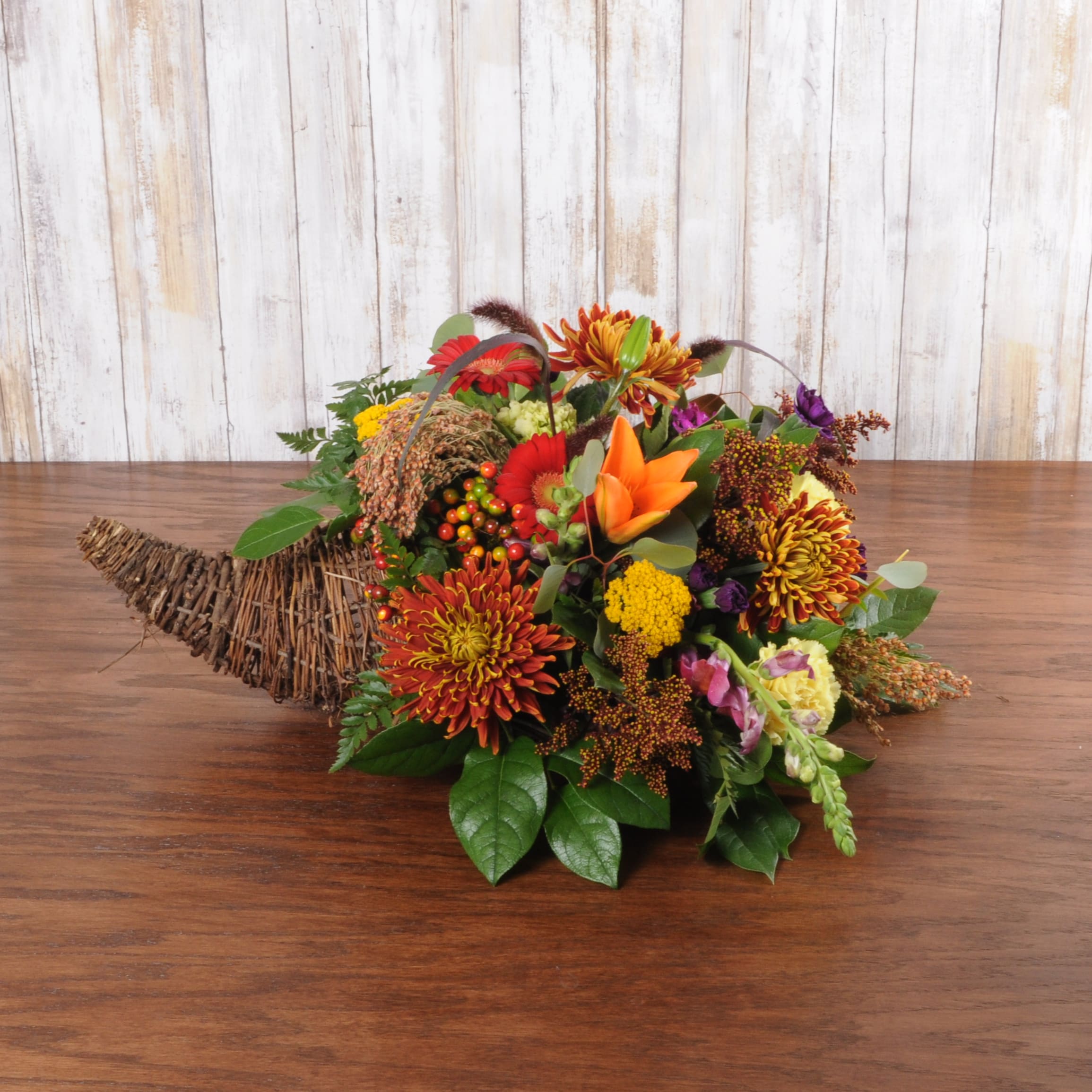 Cornucopia Cornucopia - Modern cornucopia with fresh premium flowers that includes lillies, gerbera daisies and snapdragons.
