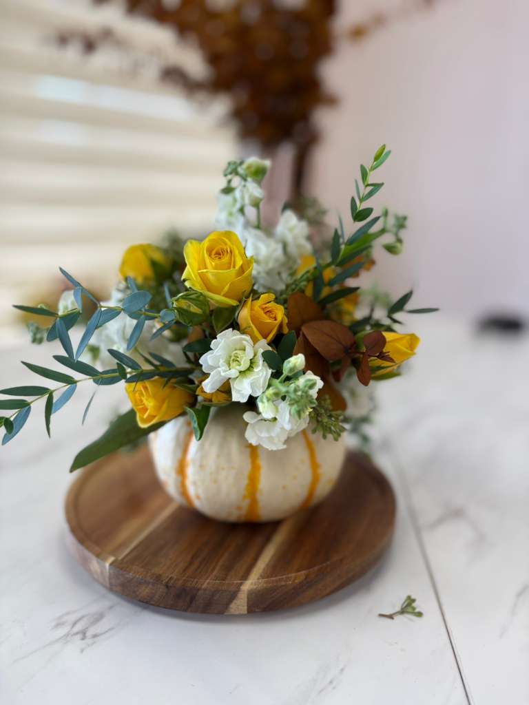 White as Autumn - A delicate and elegant design with a white pumpkin base, fresh flowers in neutral tones, and golden touches that celebrate the beauty of autumn with subtlety and charm. Perfect for decorating your home or as a gift during this special season