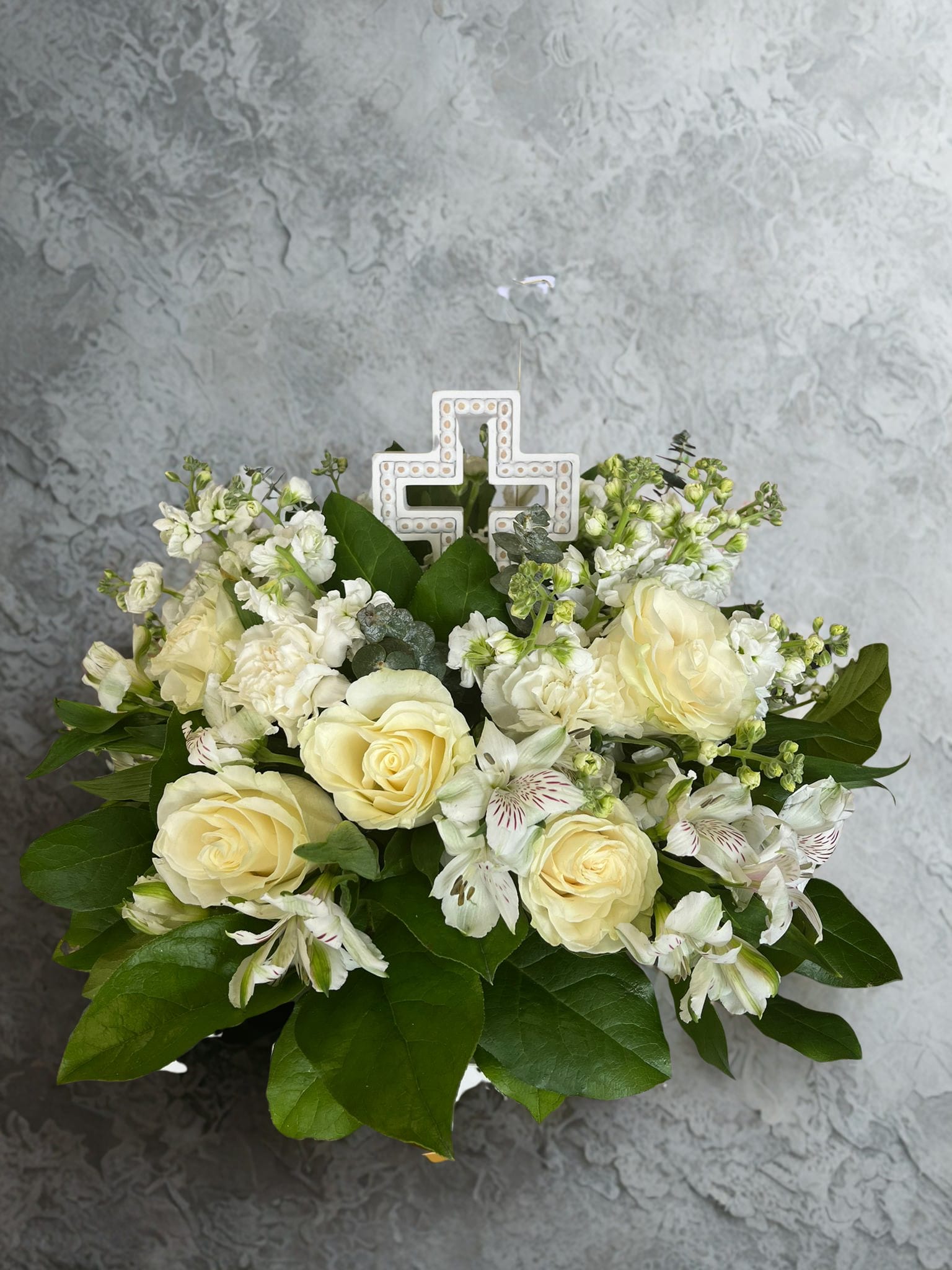 Abrazo eterno - eternal hug “Same Day Flower Delivery in Orange County” -  Round Funeral Centerpiece A delicate round floral arrangement, made with fresh flowers in soft white tones, symbolizes peace, purity, and hope. Its harmonious design makes it ideal for farewell ceremonies, wakes, or funerals, conveying a message of respect and comfort to the family. Furthermore, due to its versatile and elegant style, it can also be placed in the home after the mourning, as a memento filled with serenity and light in honor of the loved one.    Centro de mesa fúnebre redondo Un delicado arreglo floral en forma redonda, elaborado con flores frescas en tonos blancos y suaves, símbolo de paz, pureza y esperanza. Su diseño armonioso lo hace ideal para acompañar ceremonias de despedida, velorios o funerales, transmitiendo un mensaje de respeto y consuelo a la familia. Además, por su estilo versátil y elegante, puede colocarse también en casa después del duelo, como un recuerdo lleno de serenidad y luz en honor al ser querido. 