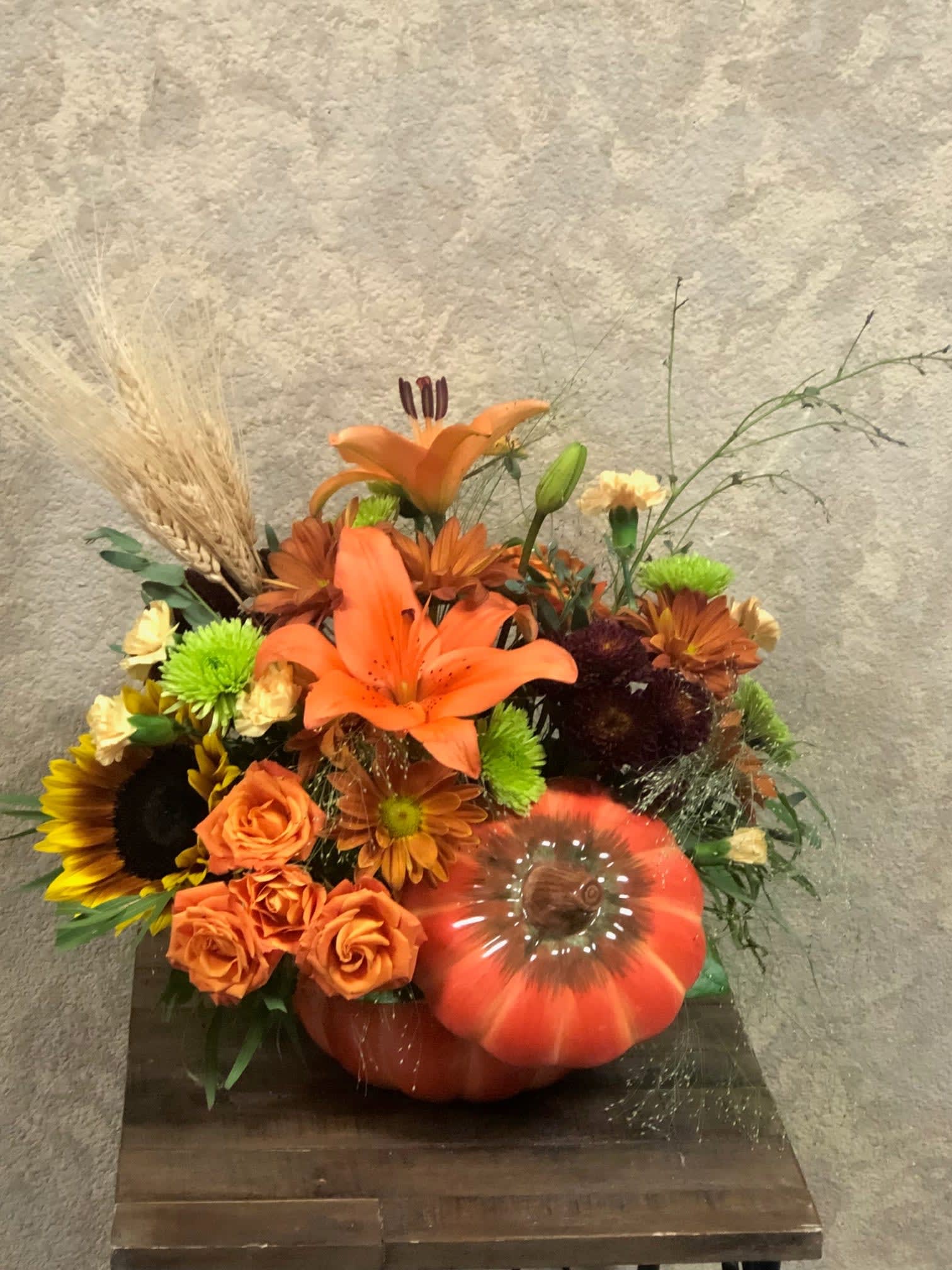 Pumpkin Harvest in cookie jar Pumpkin Harvest in cookie jar - Celebrate this season with this cute fall arrangement that turns into a cookie jar to store all your Halloween candy! Type of Flowers: Yellow Sunflowers, Orange Asiatic Lillies, Orange Spray Roses, Ivory Mini Carnations, Fall Daisies, Green and Purple Cushion Buttons, and Dried Wheat Grass in a short pumpkin vase. Availability: All year round Substitute Available: Yes Design View: Symmetric Front Facing View Photo shown: Regular