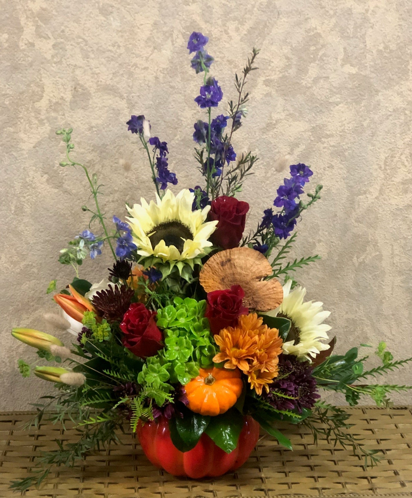 Pumpkin Spice and Everything Nice in Cookie Jar Pumpkin Spice and Everything Nice in Cookie Jar - Type of Flowers: Purple Larkspur, Red Roses, Sunflowers, Green Hydrangea, Orange Lilies, Brown Daisies, Purple Mums, and more in a pumpkin ceramic vase. Lid is not included. Availability: All year round Design View: Symmetric Front-Facing View Photo shown: Regular