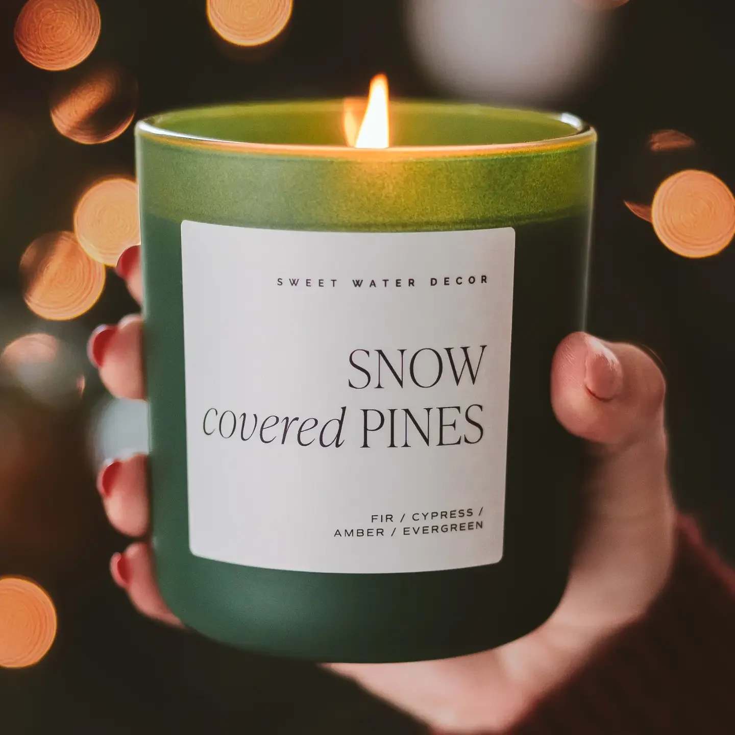 Snow Covered Pines 15 oz Soy Candle, Matte Jar Snow Covered Pines 15 oz Soy Candle, Matte Jar - Our green matte jar is a Christmas decor staple - and it's fragrance is made for winter. Fraser Fir is an iconic winter scent that makes this Christmas candle a best-seller. Add this festive holiday candle to your seasonal display for customers to add under their tree (or their holiday decor). SCENT NOTES: • Top: Cypress, Evergreen • Middle: Cedar • Base: Fir Balsam