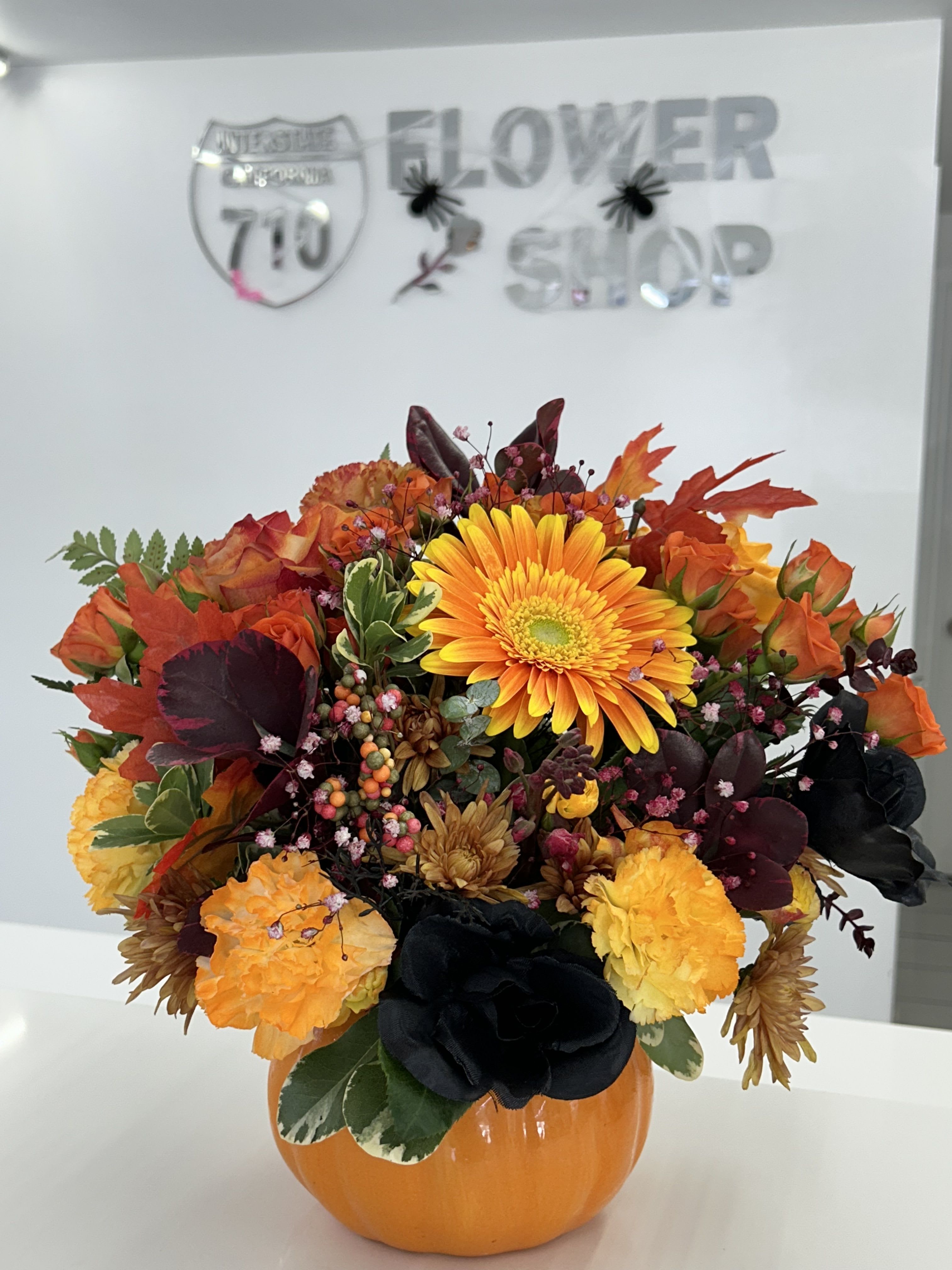 Golden Harvest Arrangement Golden Harvest Arrangement - A classic autumn bouquet bursting with seasonal charm—sunny blooms, deep wine-toned leaves, and more all nestled in a bright pumpkin container. A harvest-season favorite! Flowers included: (If some flowers and/or the vase are not available there will be minor substitutions.)