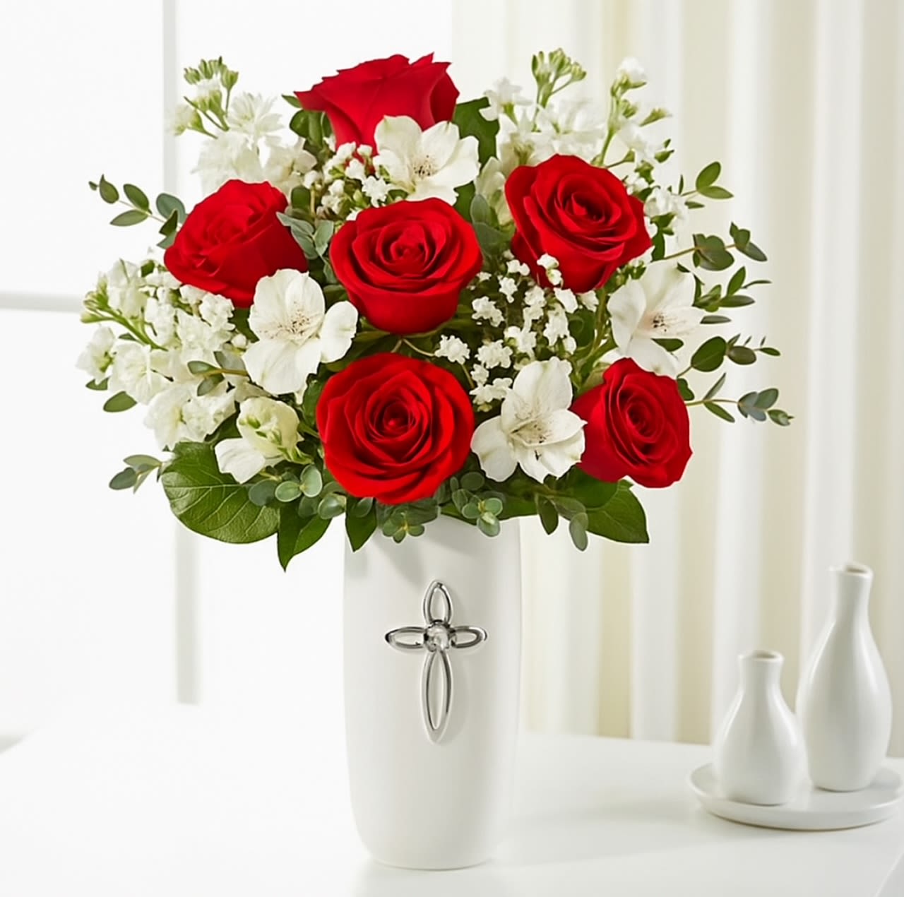 Red Graceful Cross Red Graceful Cross - The Red Graceful Cross Vase offers a gentle expression of sympathy with its soothing blend of red roses and white blooms. Arranged in a classic vase, this elegant mix symbolizes peace, hope, and heartfelt remembrance—bringing comfort in times of loss.