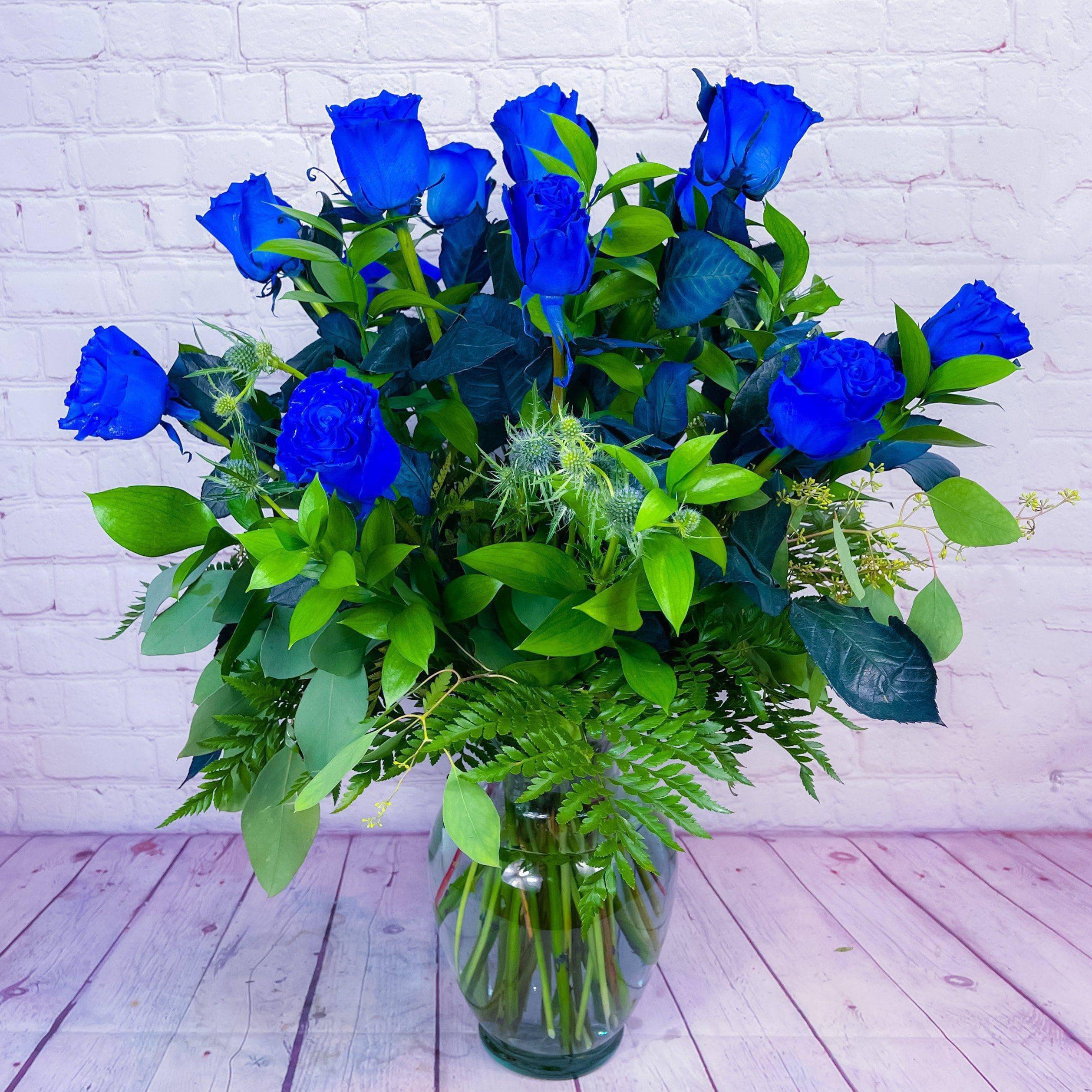 Blue Rose Bouquet Blue Rose Bouquet - Our Magically bright blue rose bouquet are the perfect gift for a friend or loved one on their special day. Whether they are celebrating a major success, commemorating a milestone, or in need of a pick me up, this impressive array of jewel toned blue roses will help them do just that!  Includes: • Dyed Blue Roses • Clear Vase