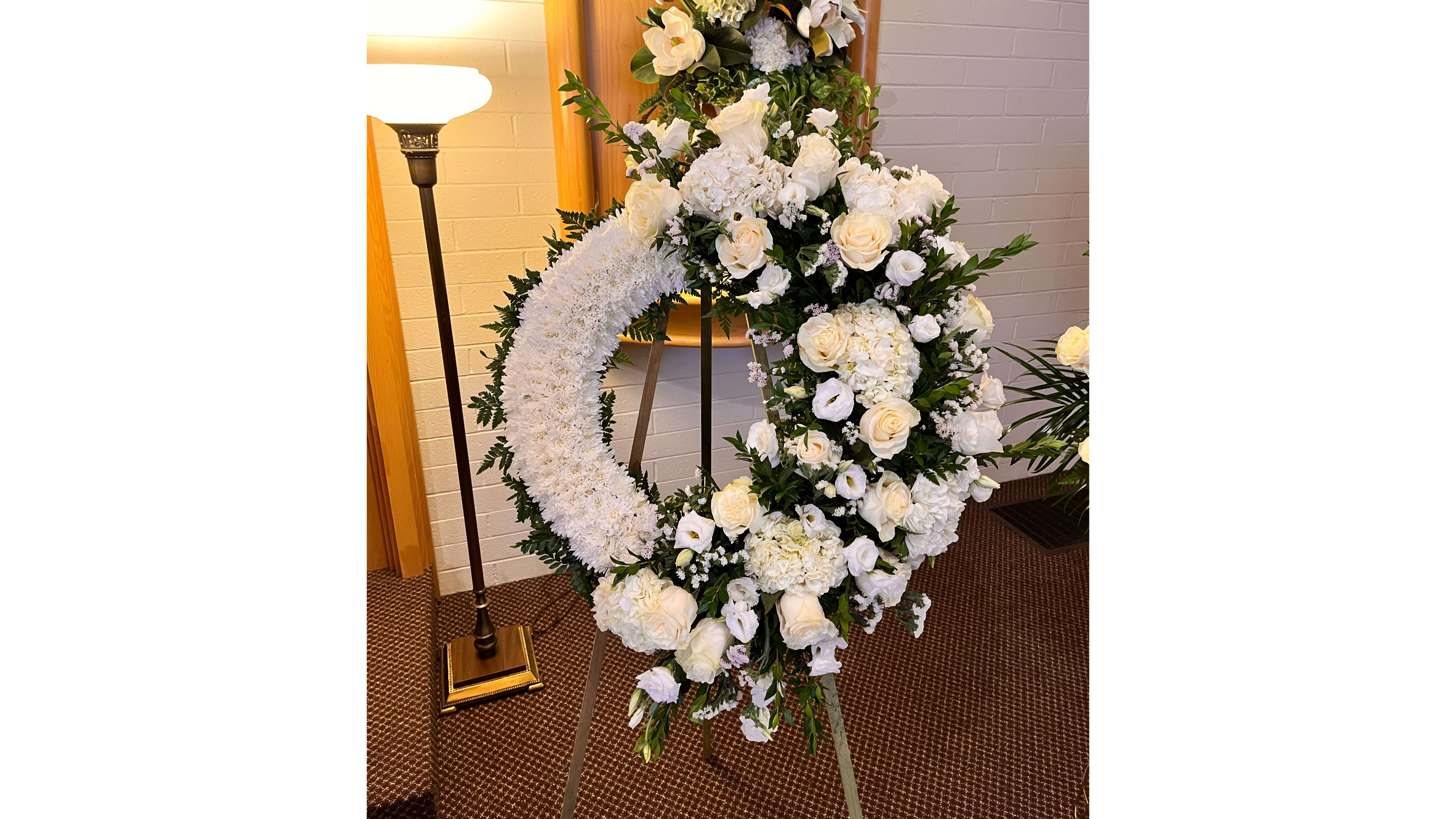 White Garland Wreath  White Garland Wreath  - A unique design of roses, lisianthus, hydrangeas, greens and statice.