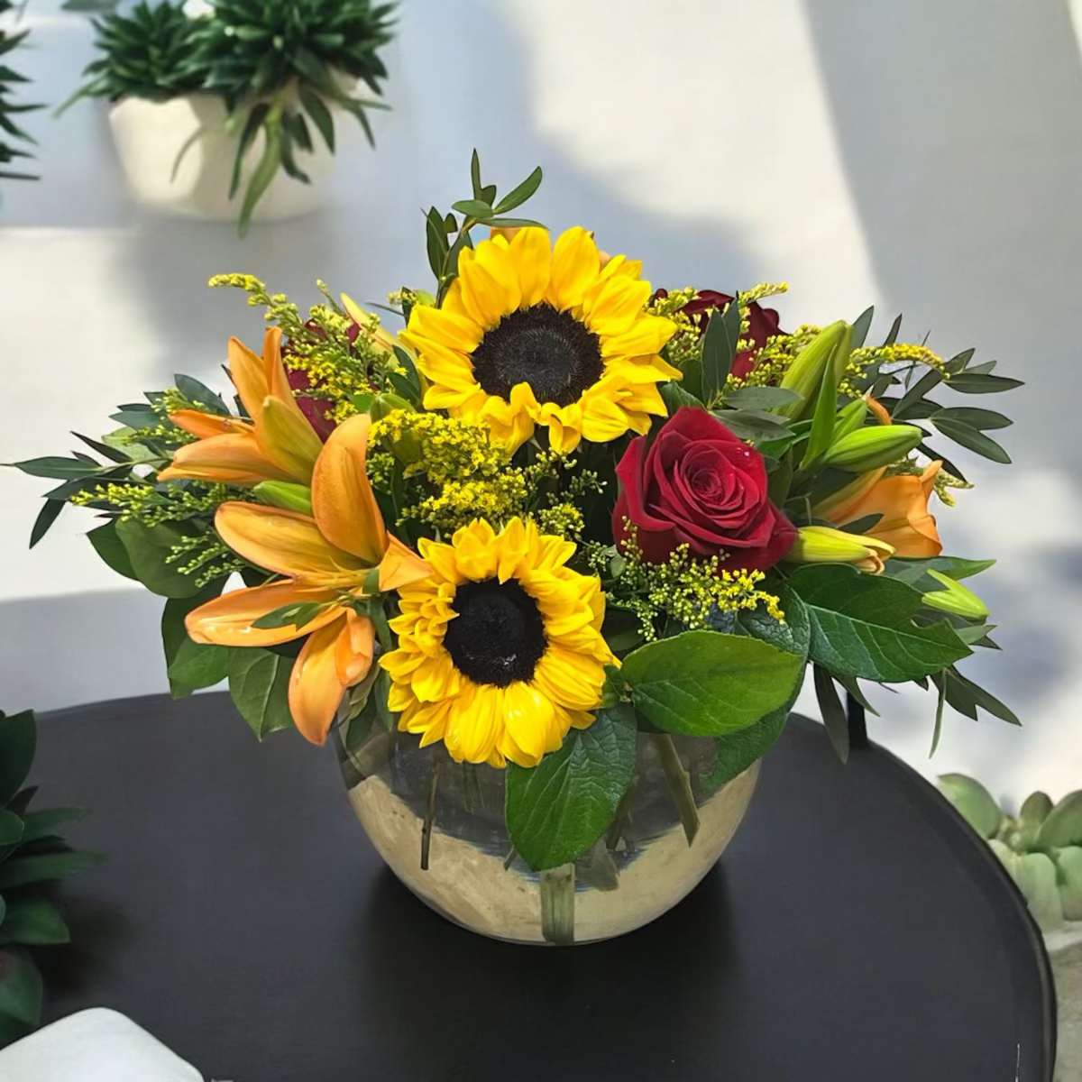 Autumn Delight Autumn Delight - Celebrate Autumn with our Autumn Delight designed in a clear glass bowl with sunflowers, roses, lilies and other blooms.