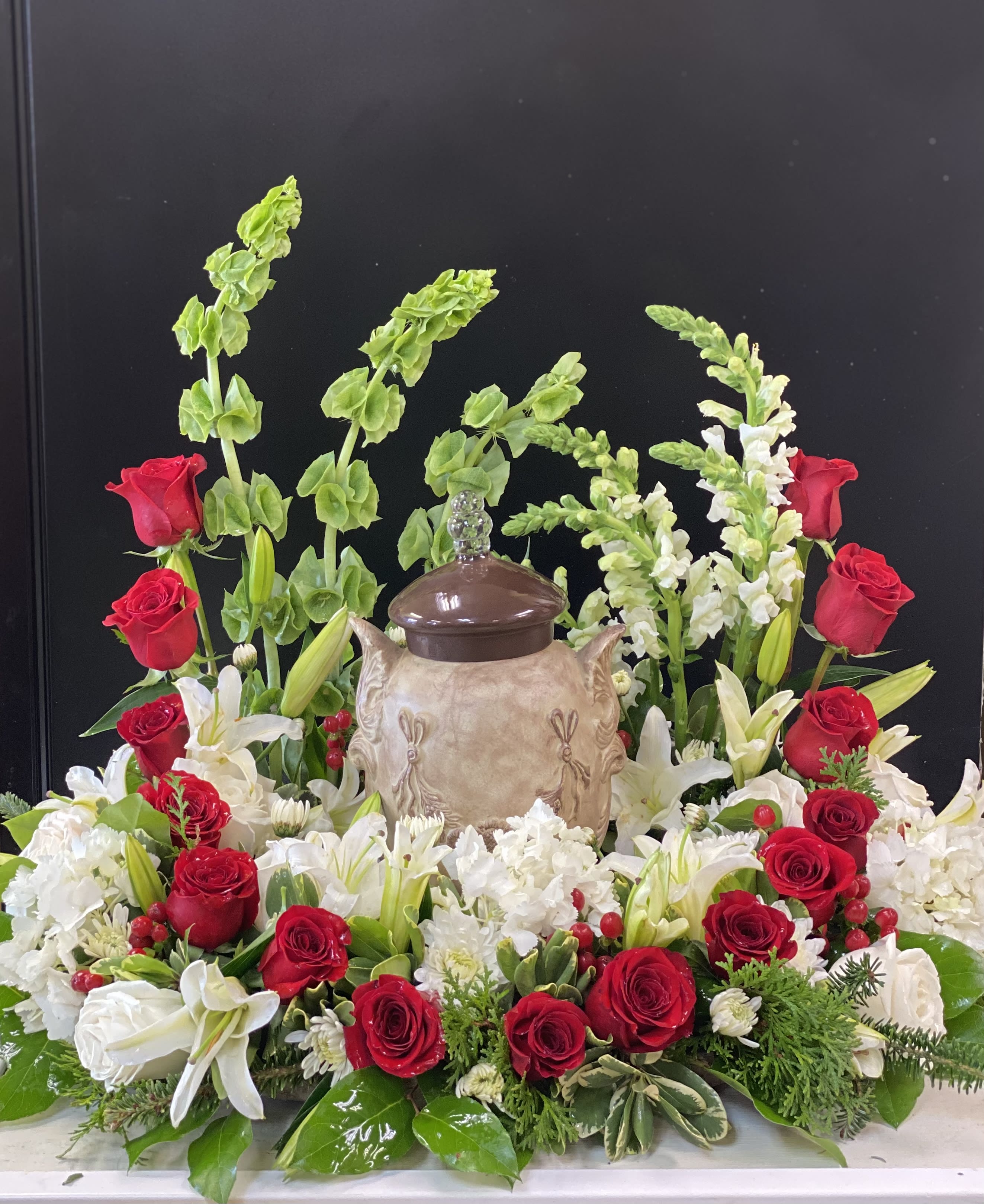 Circle of love Circle of love - Premium shown. Urn not included. A circle of love to celebrate the life of your loved one. Designed with red roses, hydrangeas, white rose, lilies and more. 18 inch and 24 inch