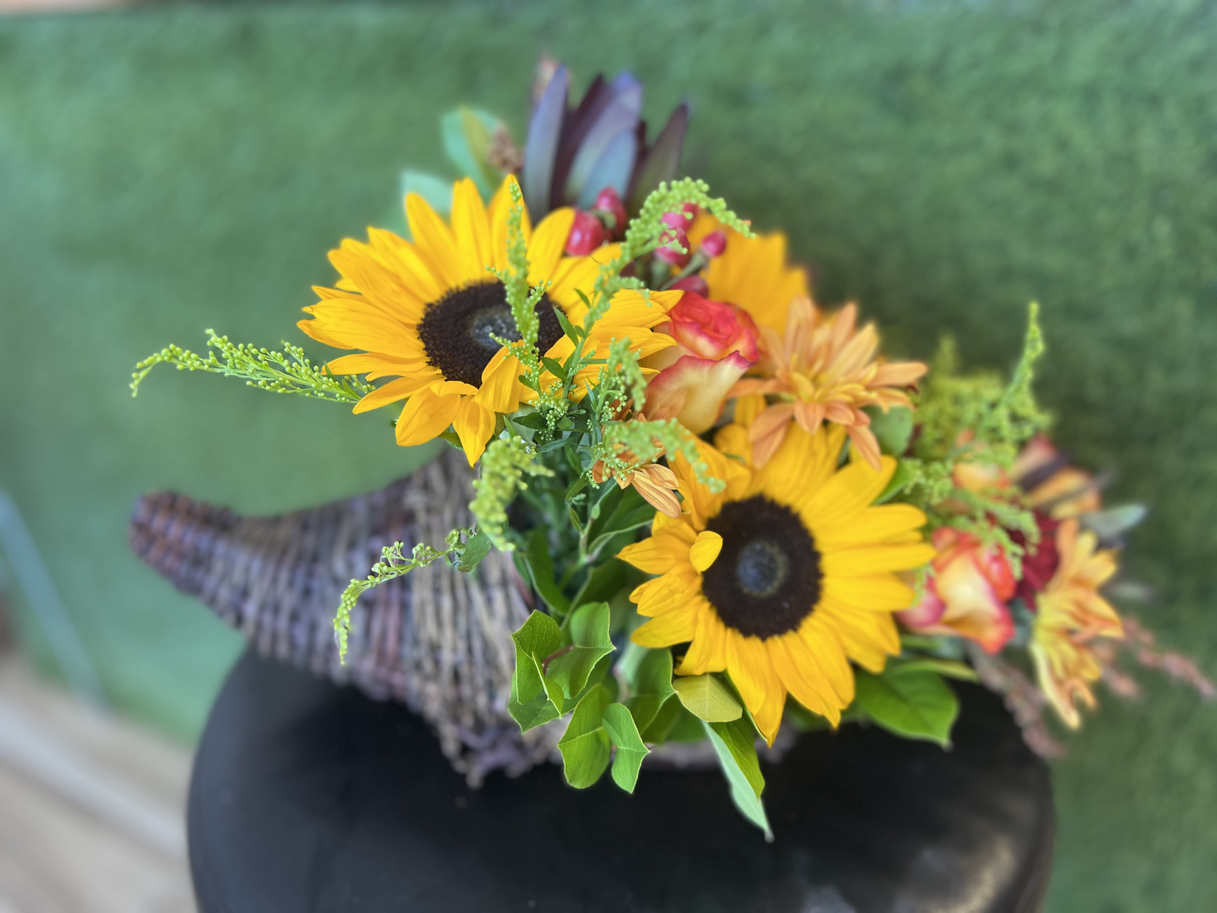 Cornucopia  Cornucopia  - Celebrate the season of Thanksgiving with this traditional symbol of autumnal abundance. The perfect Thanksgiving table decoration, this beautiful cornucopia is rendered as a horn-shaped wicker basket filled with fall flowers and harvest wheat. Also, ideal for the kitchen counter, coffee table or entryway.     SUBSTITUTION POLICY Always deliver the freshest flowers! Please note the bouquet pictured reflects our original design.  If the exact flowers or container in this arrangement are not available, our local florists will create a beautiful bouquet with the freshest available flowers.